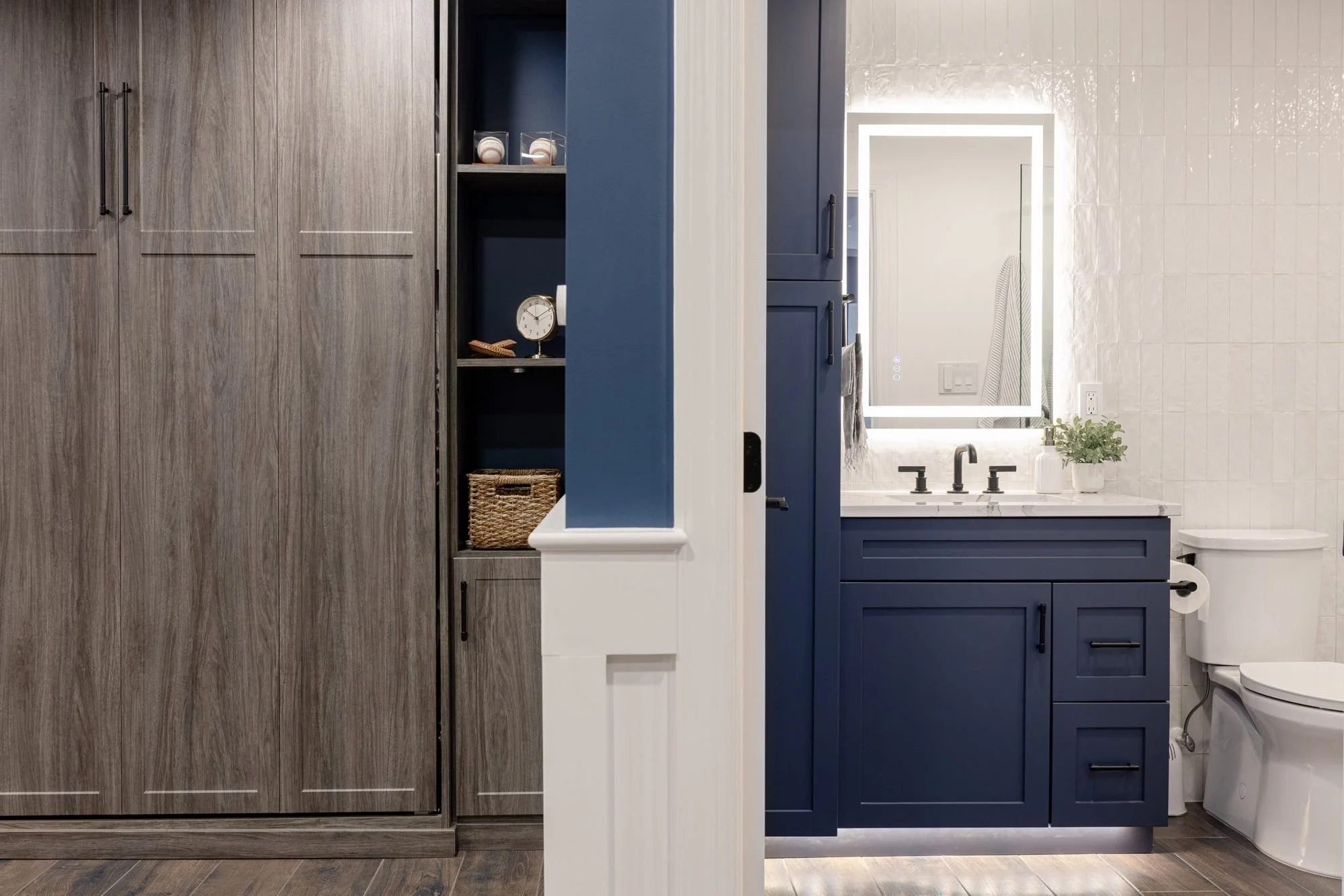 Finished basement with built-in Murphy bed cabinet and navy bathroom vanity