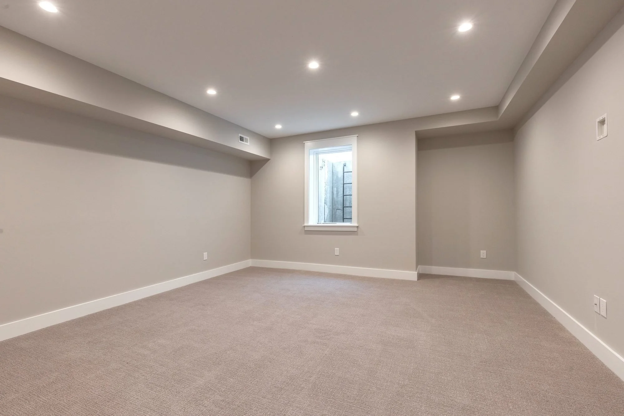 Finished basement family room with egress window and recessed lights