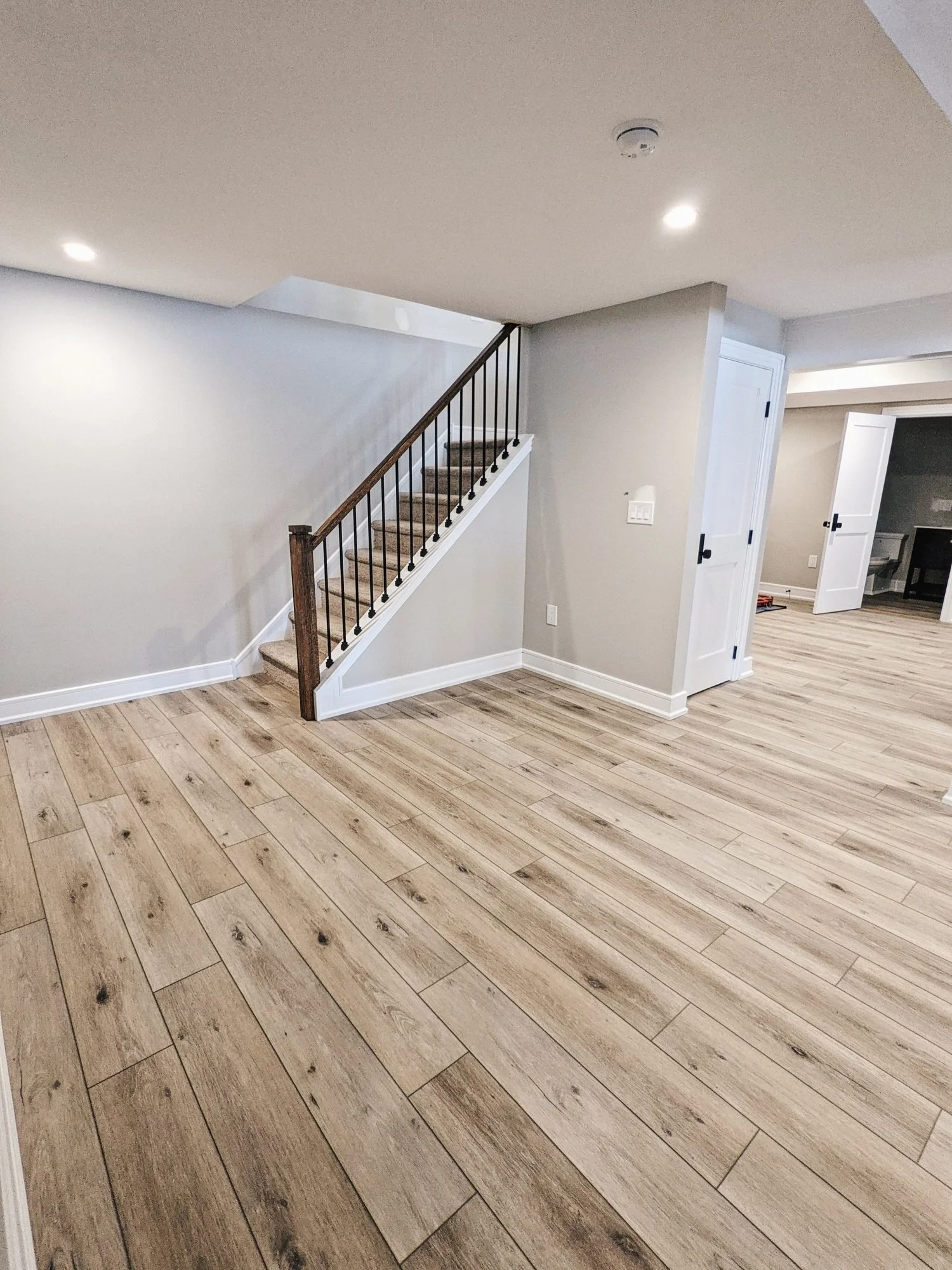 Finished basement stairway with vinyl plank flooring