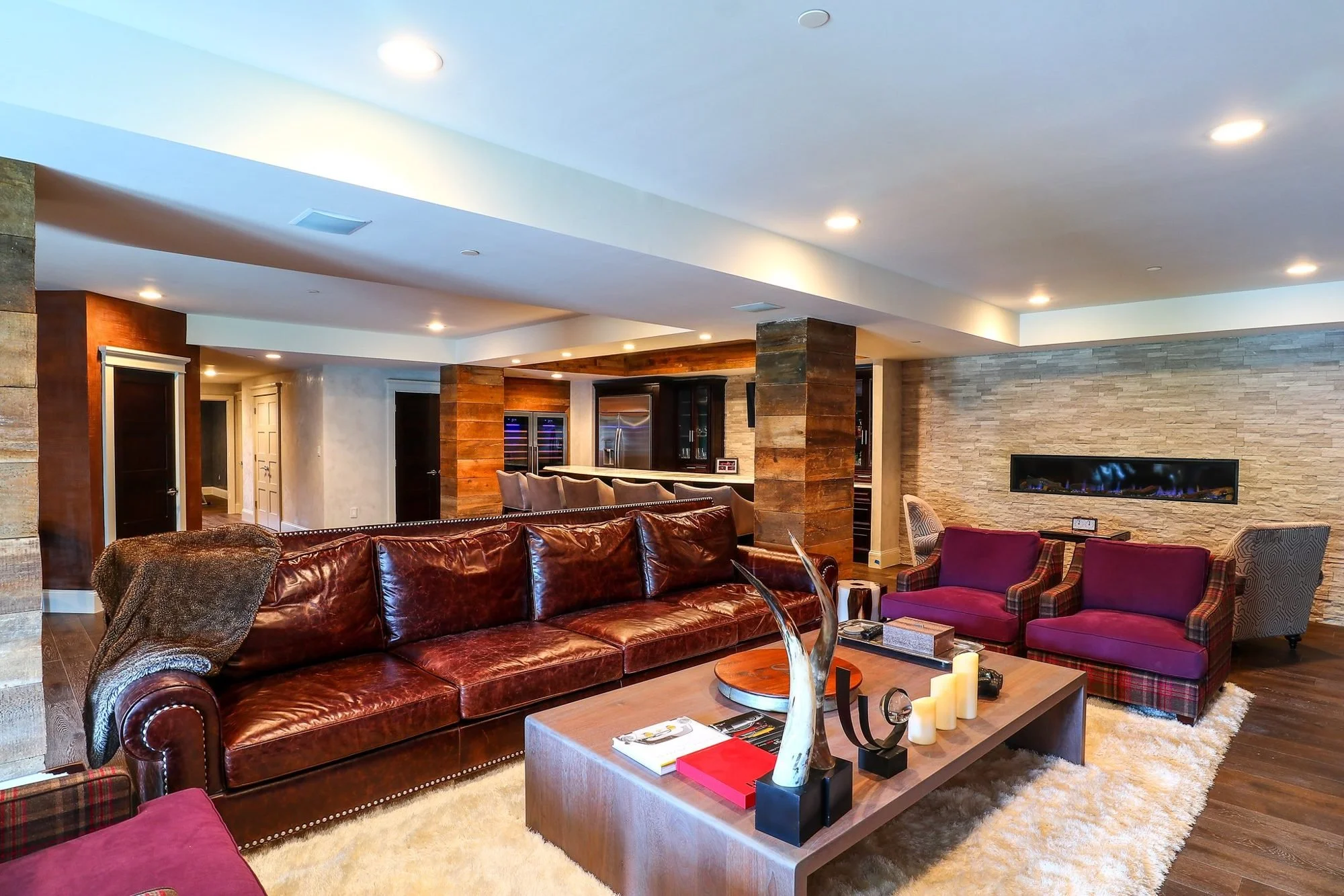 Basement family room with leather sectional and linear fireplace