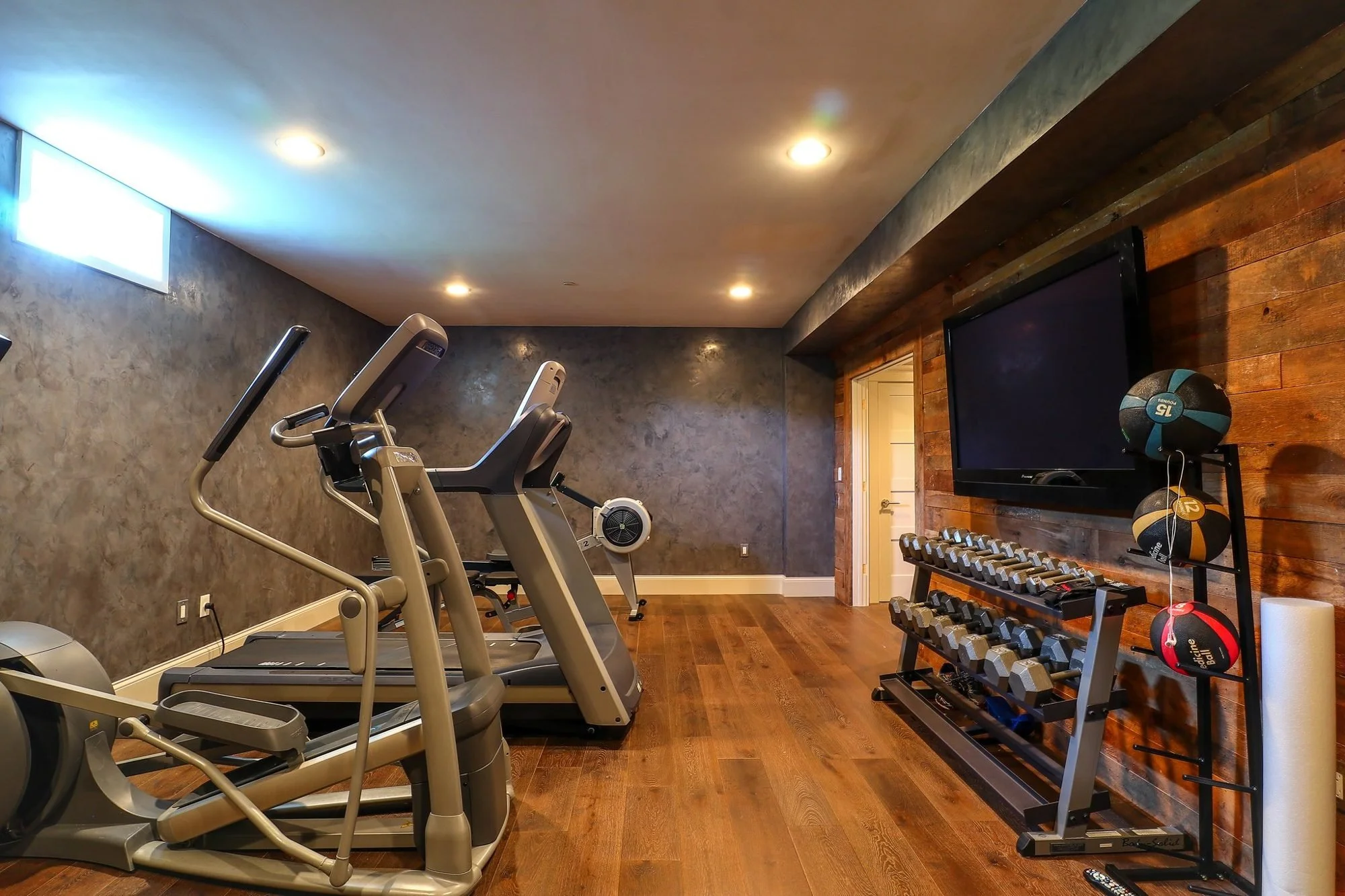 Basement home gym with reclaimed wood accent wall