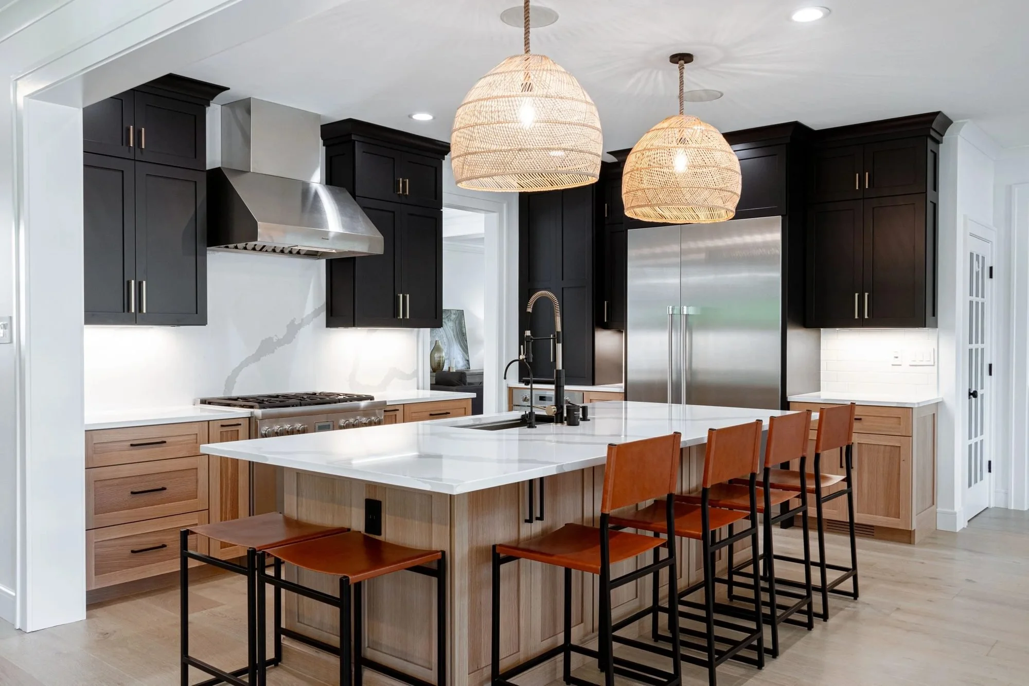 Bucks County kitchen remodel with black upper cabinets, white quartz island and rattan pendants