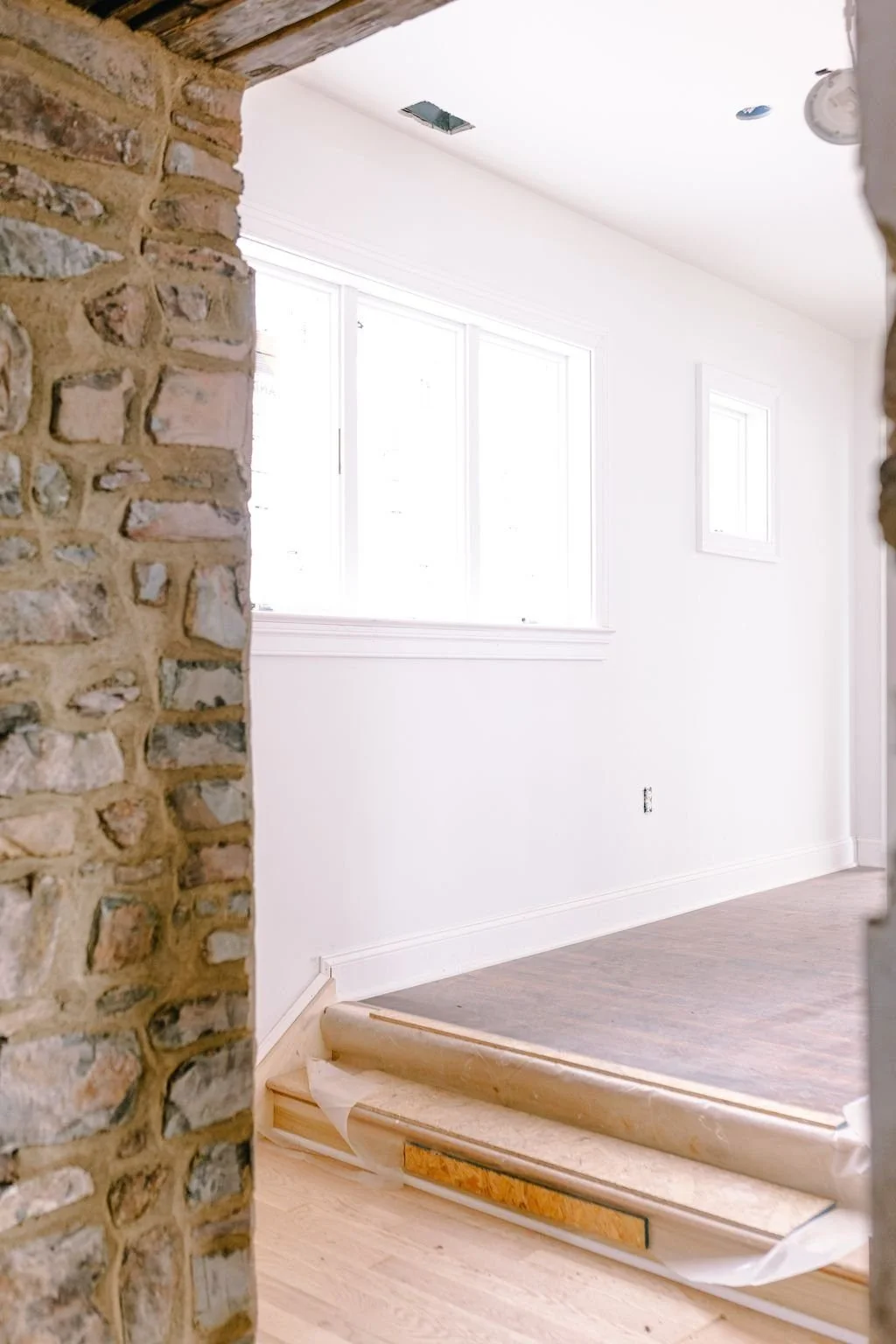 Plaster-to-stone transition between old and new spaces in a Bucks County cottage