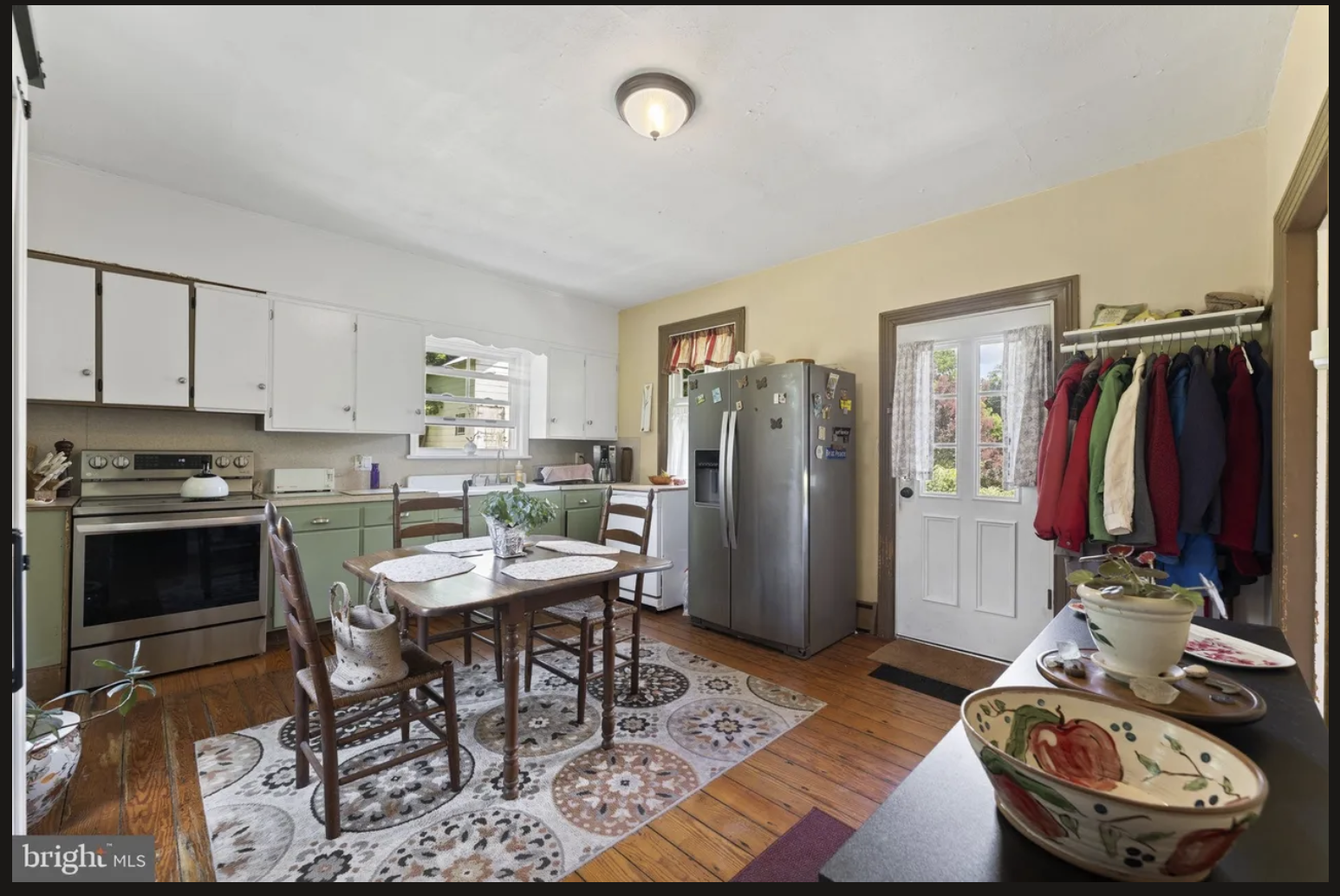 Original kitchen in an Ottsville colonial home before renovation, showing an outdated layout with laundry, coat storage, and limited workspace prior to Revival Building Group's proposed renovation.