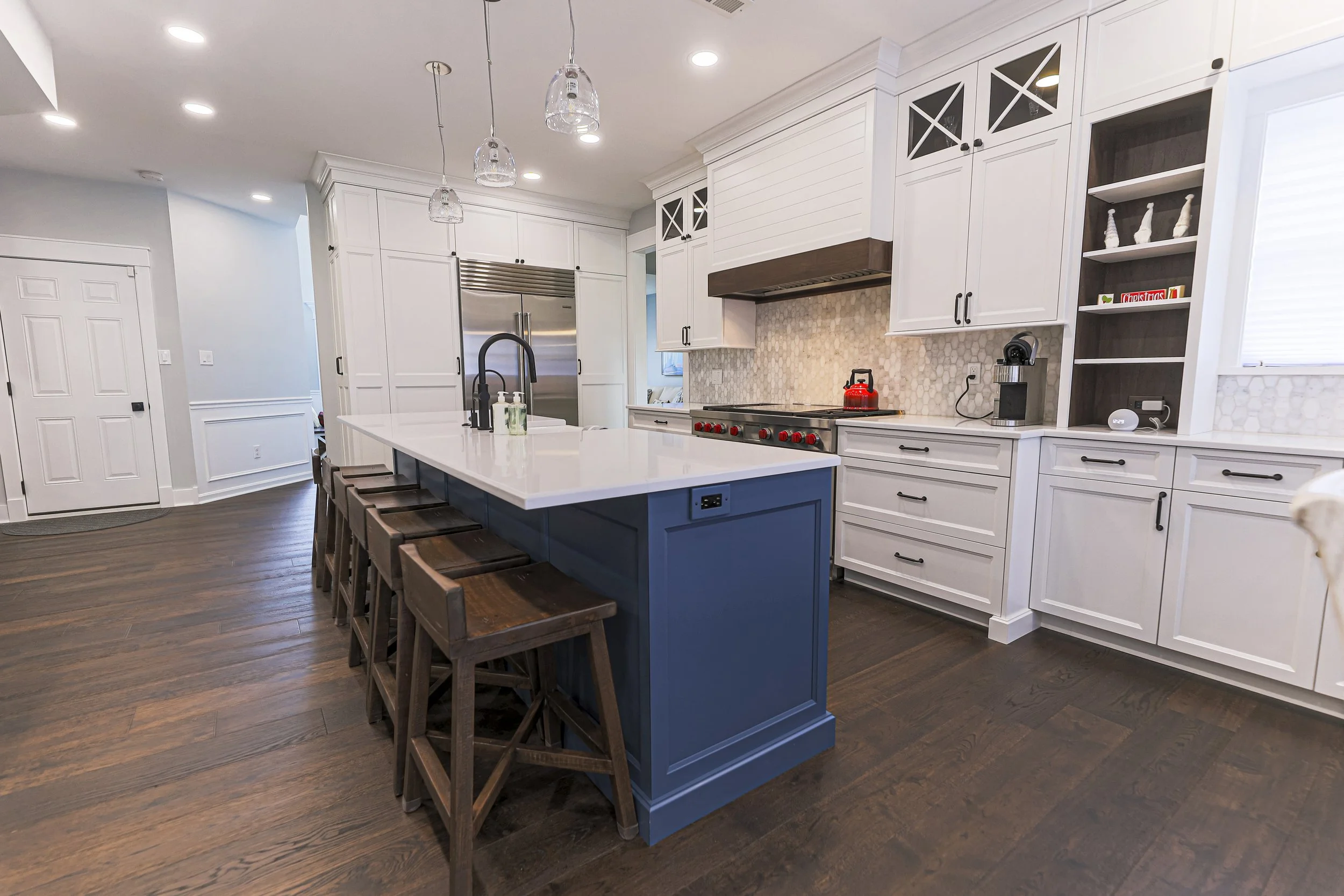 Navy kitchen island with counter seating and white perimeter cabinetry