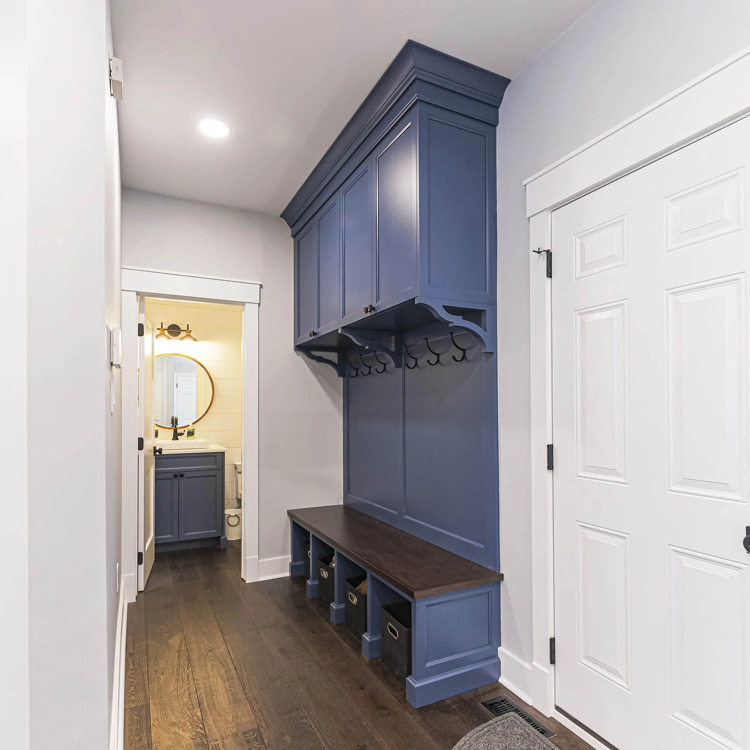 Mudroom with navy built-in bench, cubbies and coat hooks
