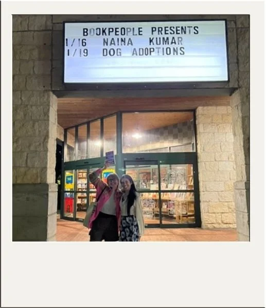 Two authors standing outside Bookpeople with their names on the marquee