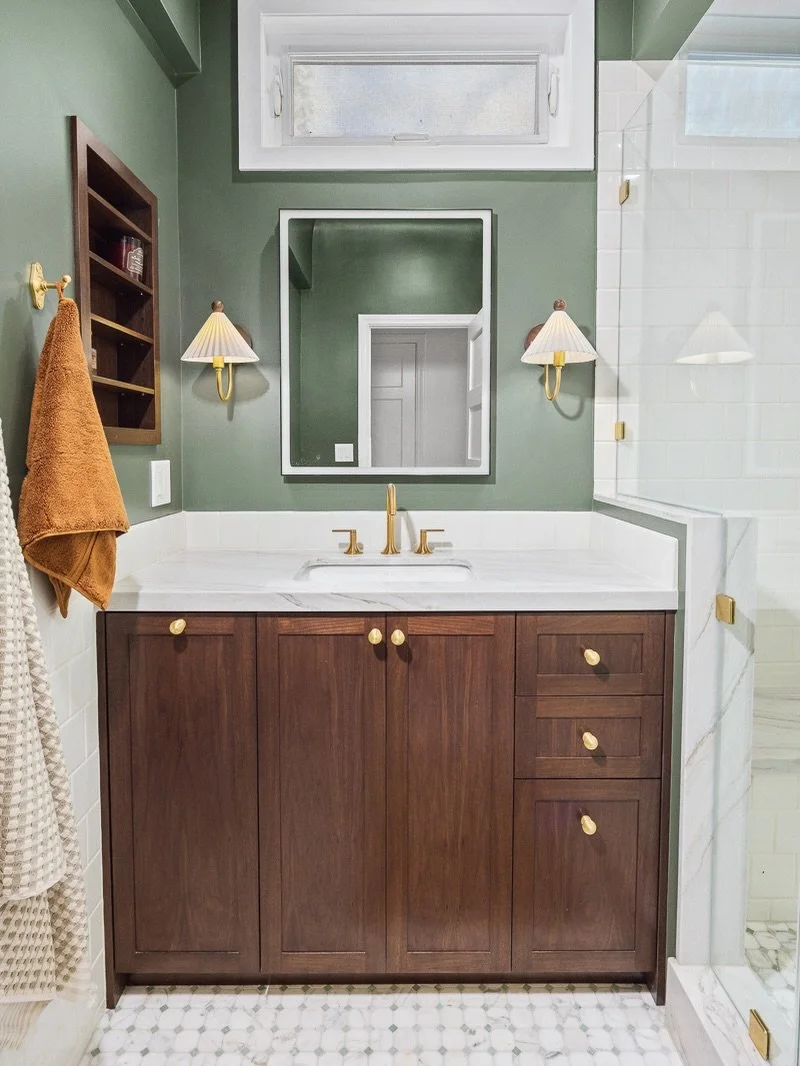 We love the look of the soft calming green paired with the darker cabinets and classic tile selections 🍃