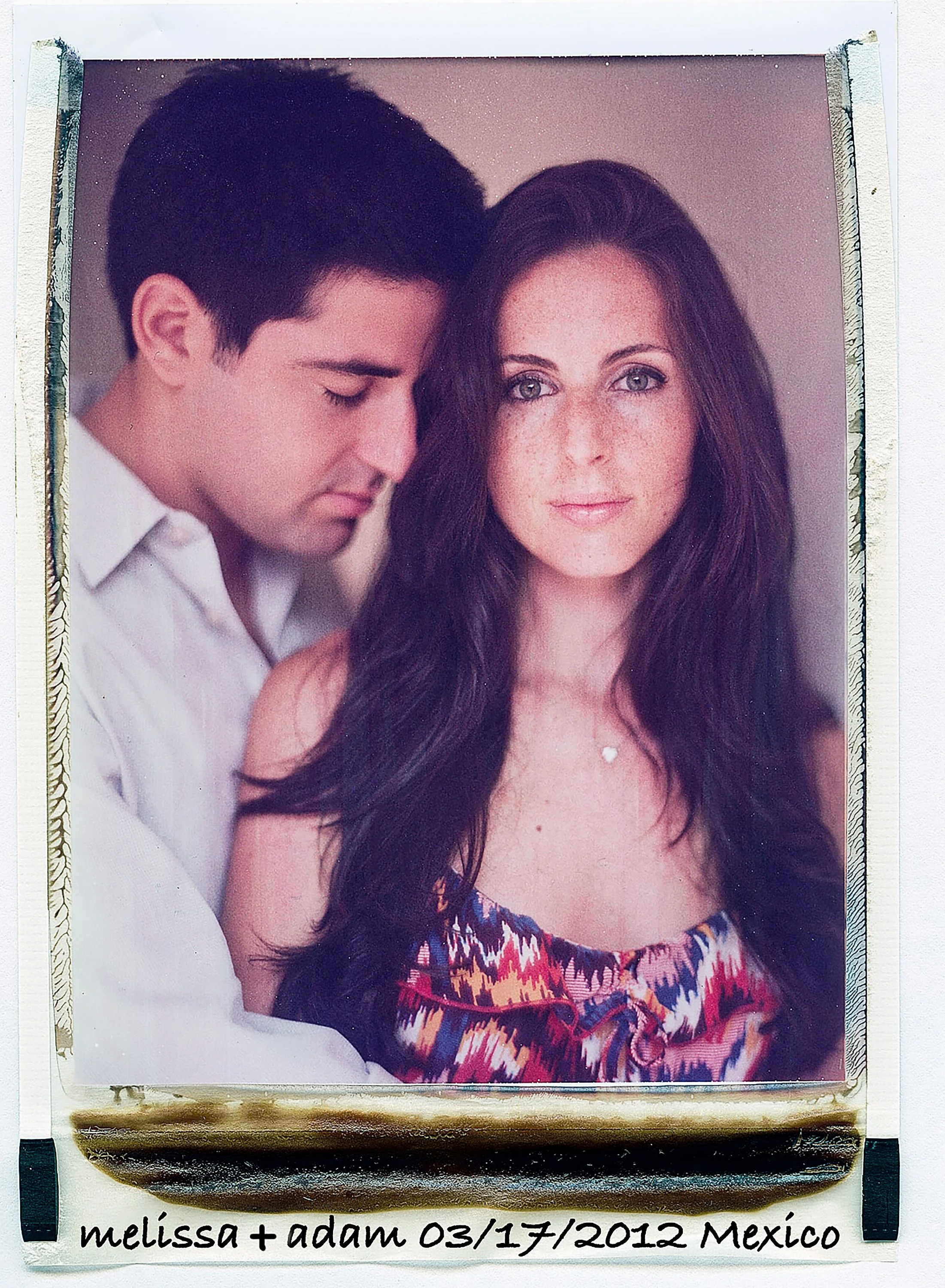 Vintage-style color instant film portrait of a couple from their engagement session, featuring a man resting his head gently on a woman's shoulder, with handwritten text at the bottom reading 'melissa + adam 03/17/2012 Mexico'.