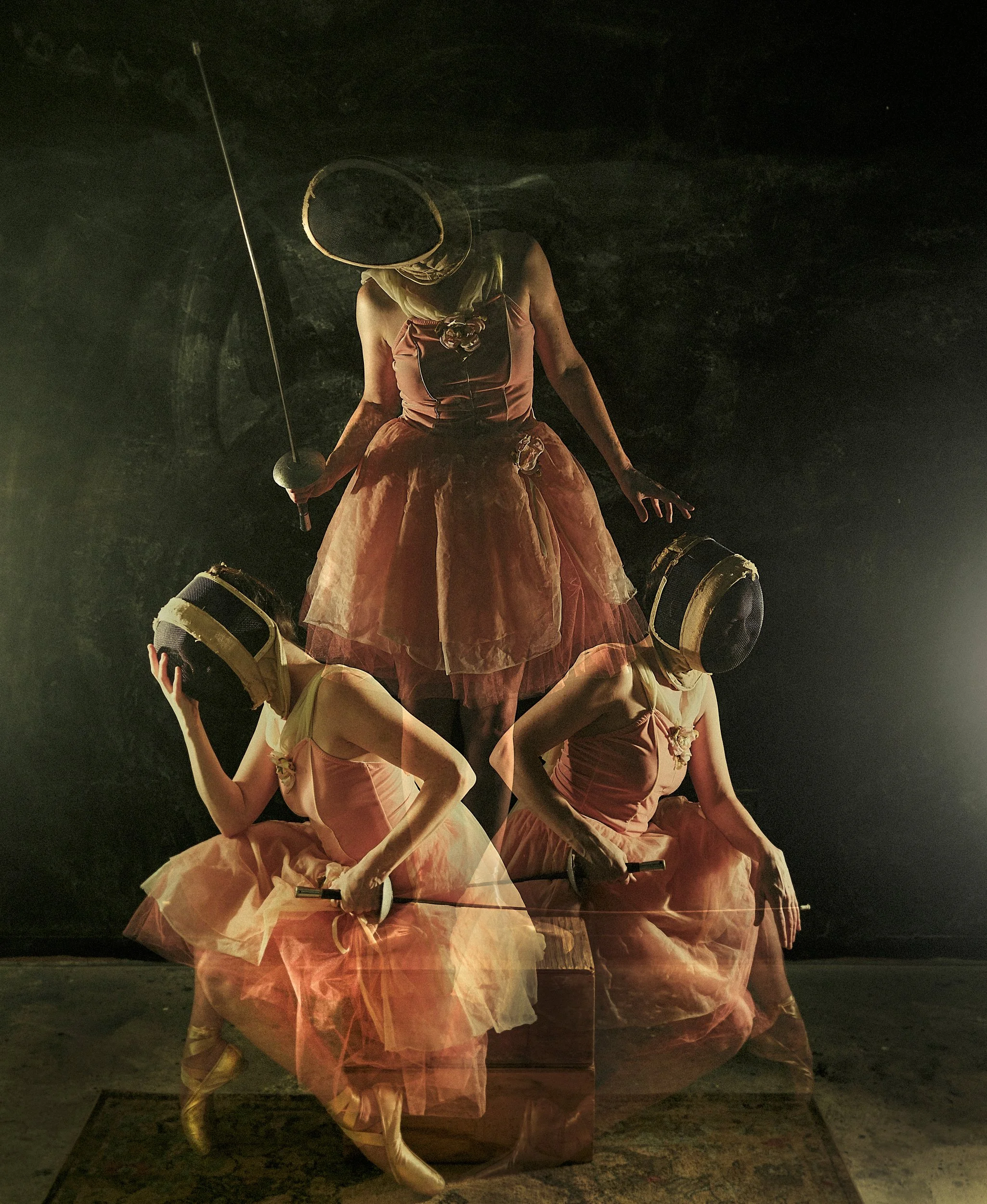 A surreal fine art color multiple exposure of a ballerina wearing a fencing mask and a pink tutu dress, holding a foil, layered in a painterly gold-toned studio setting.