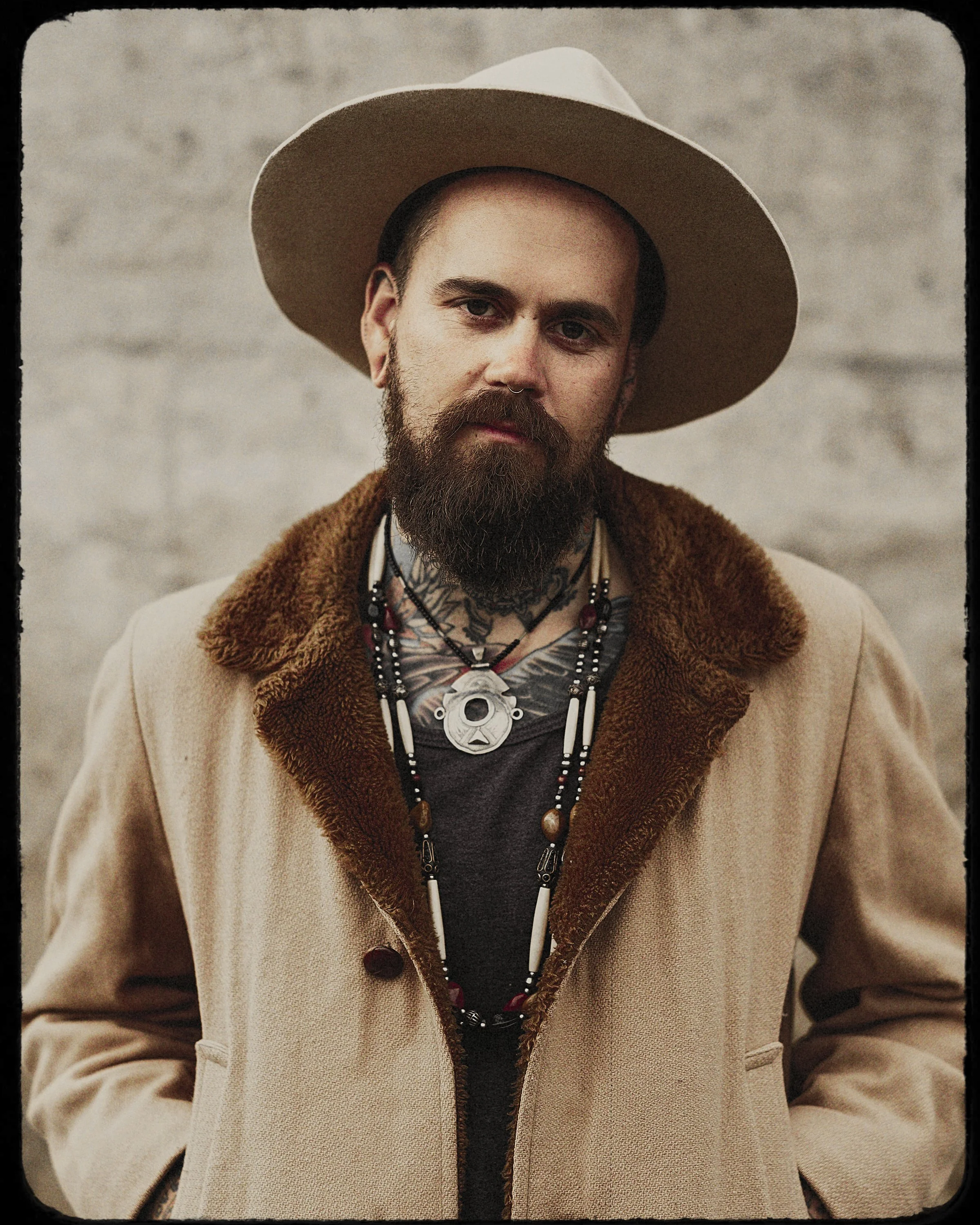 Portrait of musician David Matters, lead singer and multi-instrumentalist of Western North Carolina band Life Like Water, wearing a wide-brimmed hat and coat, photographed by Parker J. Pfister.