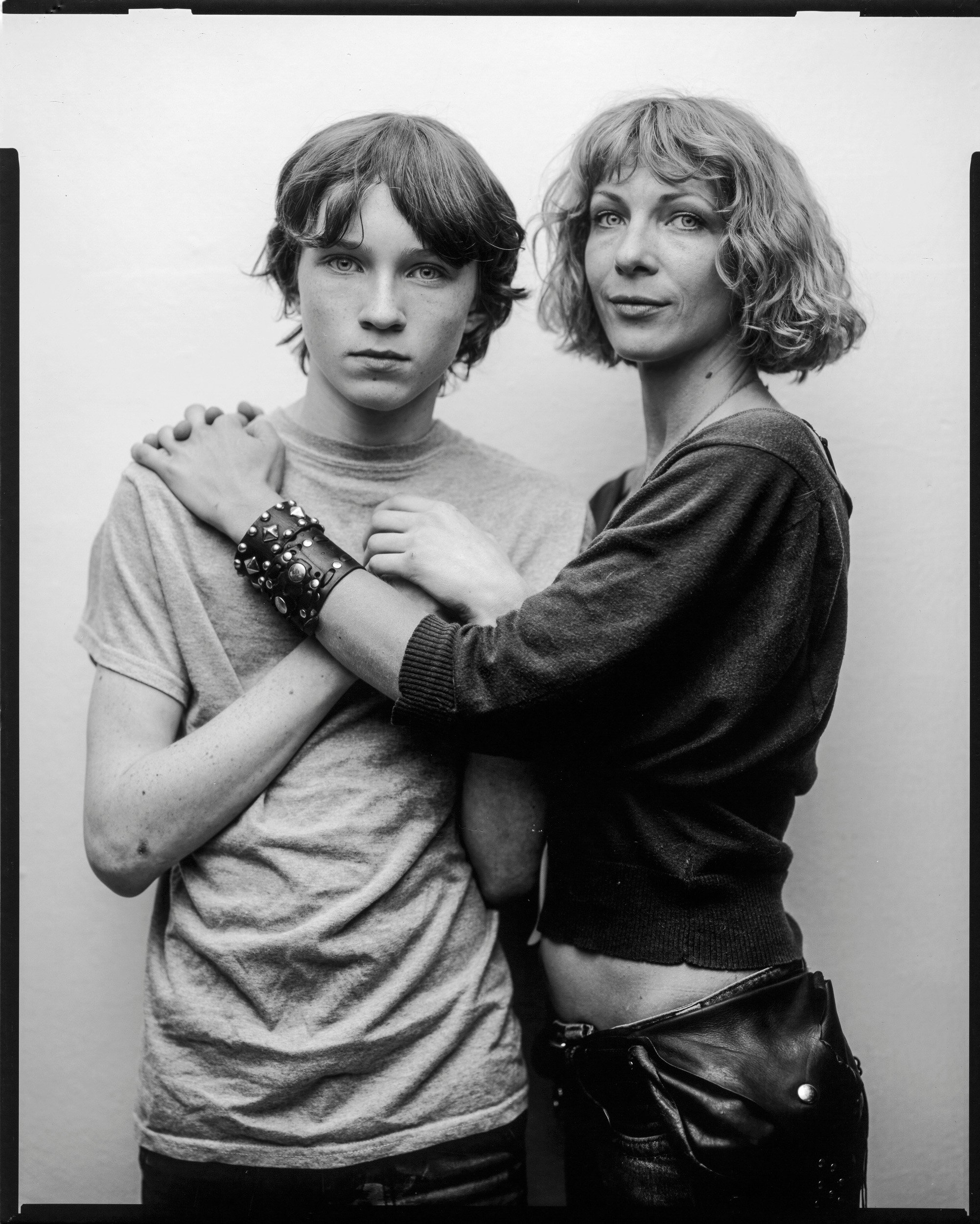 Stark black and white large format film portrait of a blonde mother with her arm around her teenage son's shoulder in Madison County North Carolina by Parker J Pfister