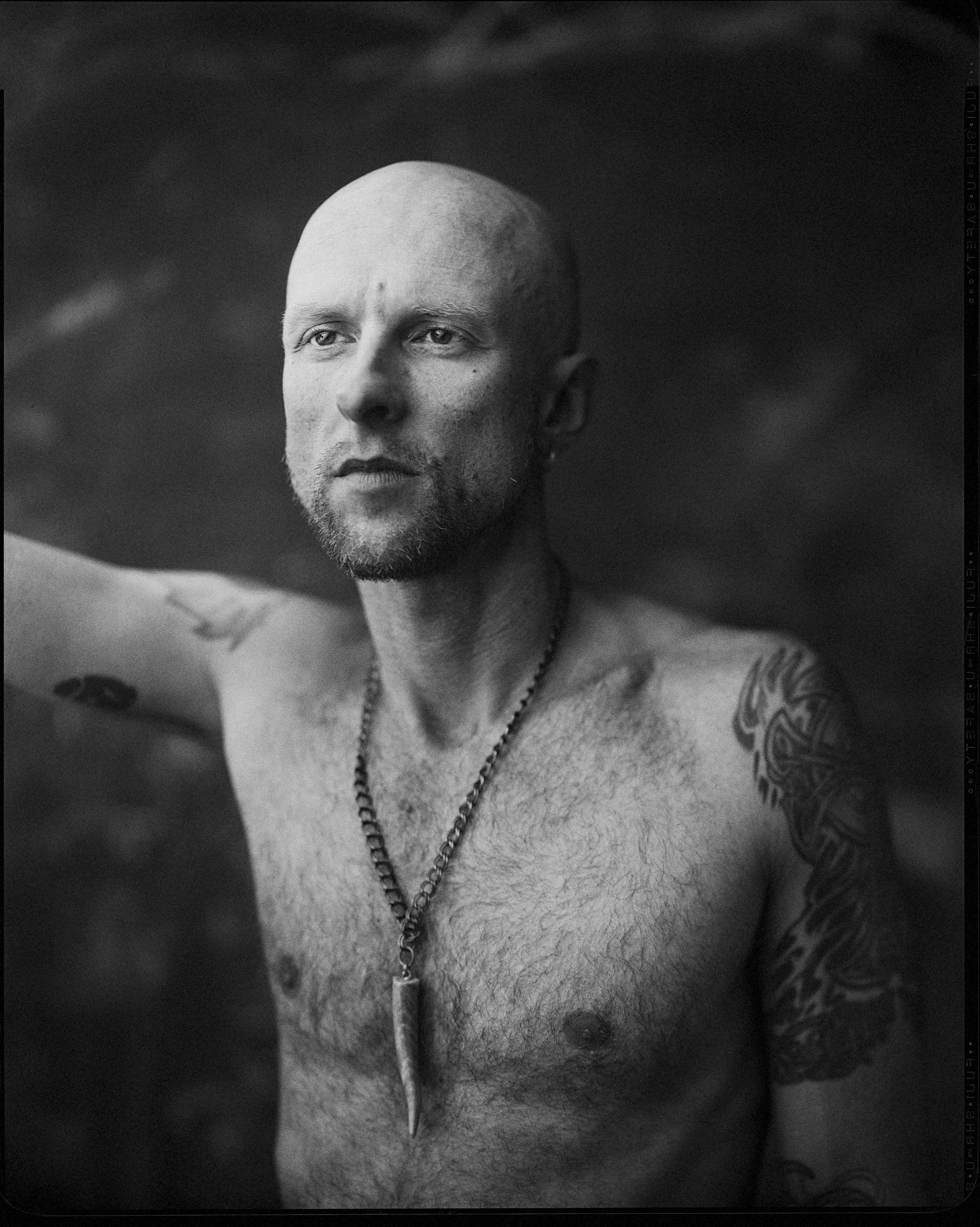 Black and white shirtless portrait of Western North Carolina musician J Miles wearing a horn pendant necklace, fine art 8x10 paper negative print by Parker J. Pfister.