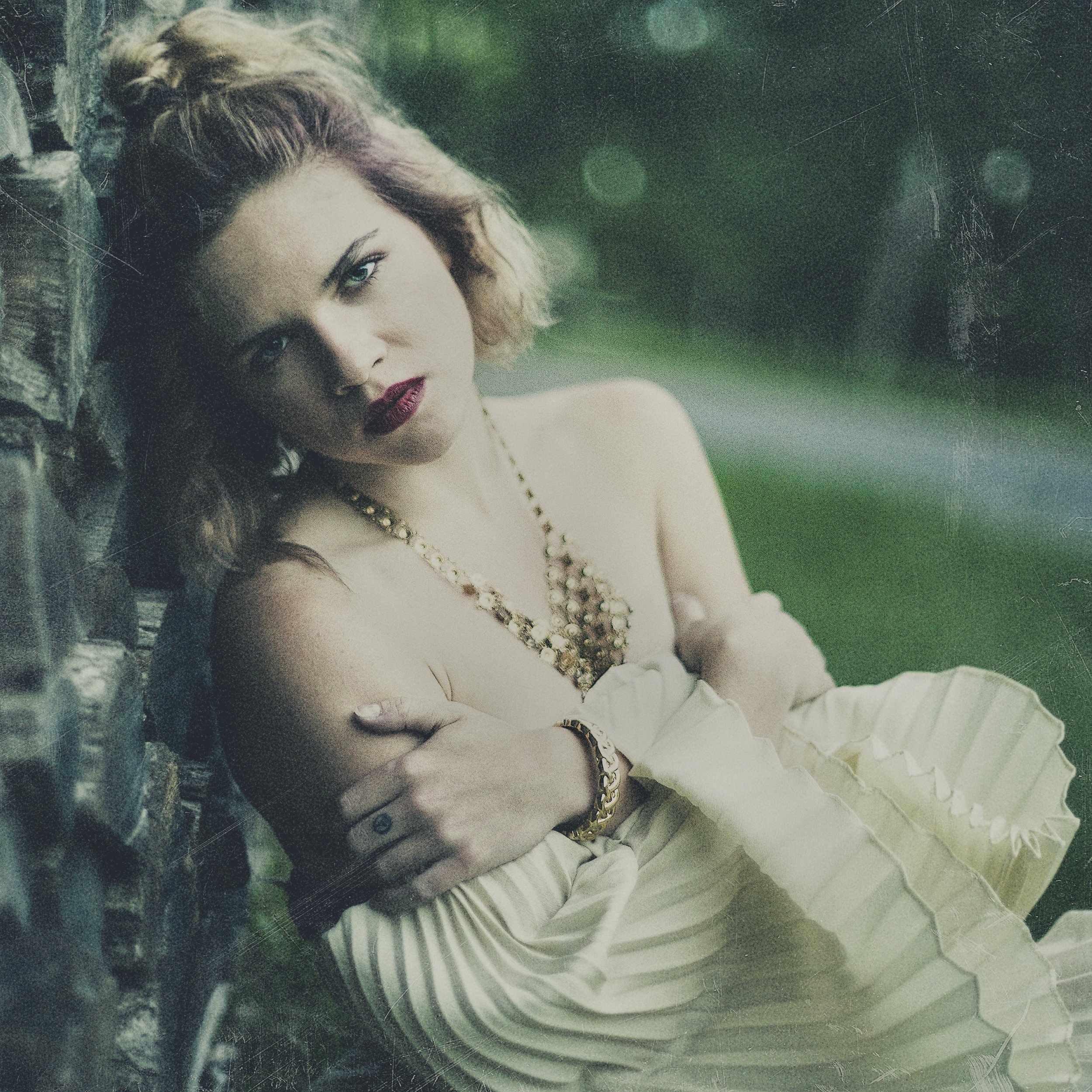 Atmospheric fine art portrait of singer Ivy Hawkins in a white dress, resting against a vintage car, photographed by Parker J. Pfister.
