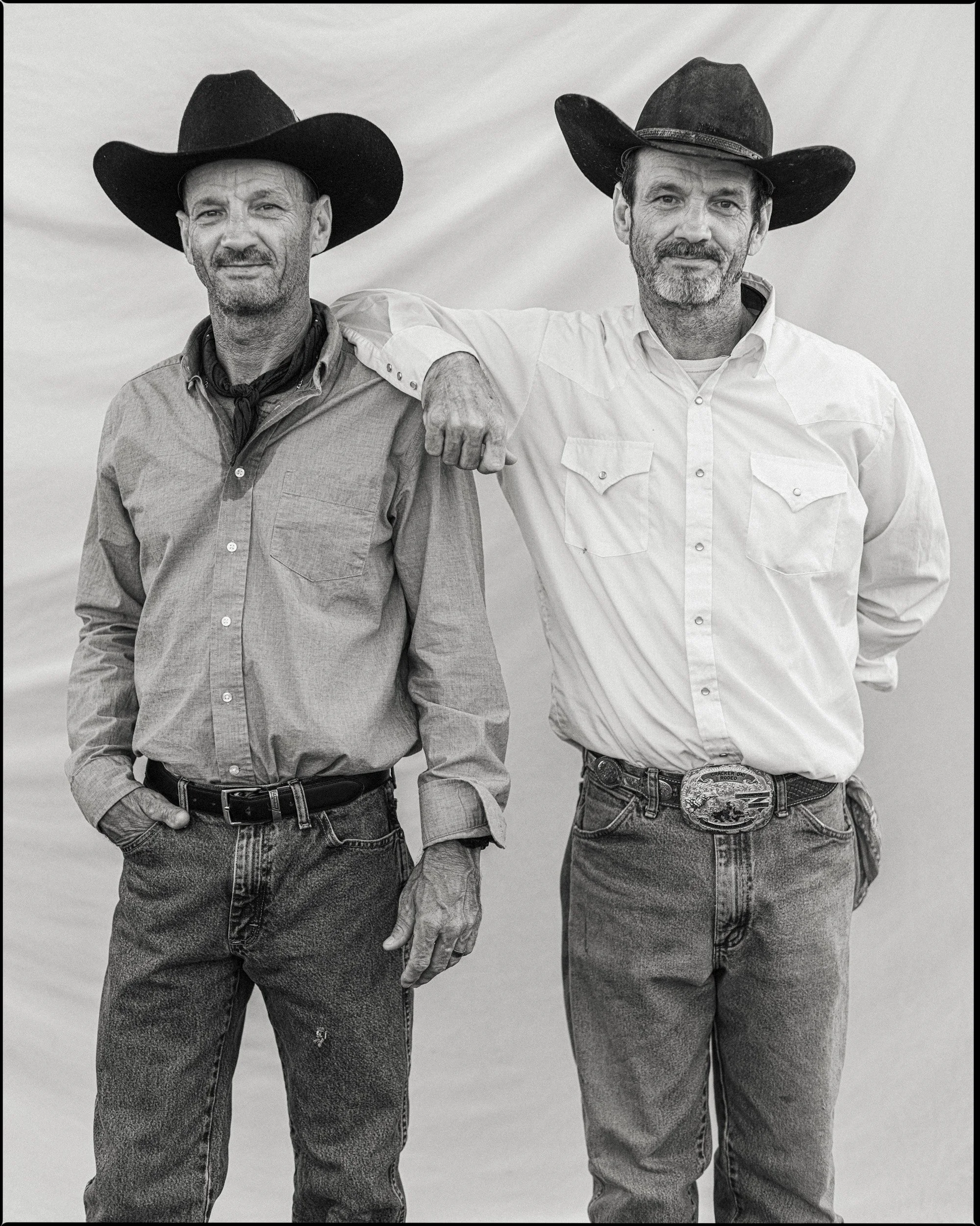 Editorial black and white 8x10 large format film portrait of twin brothers in cowboy hats standing shoulder to shoulder at the Madison County Rodeo in North Carolina