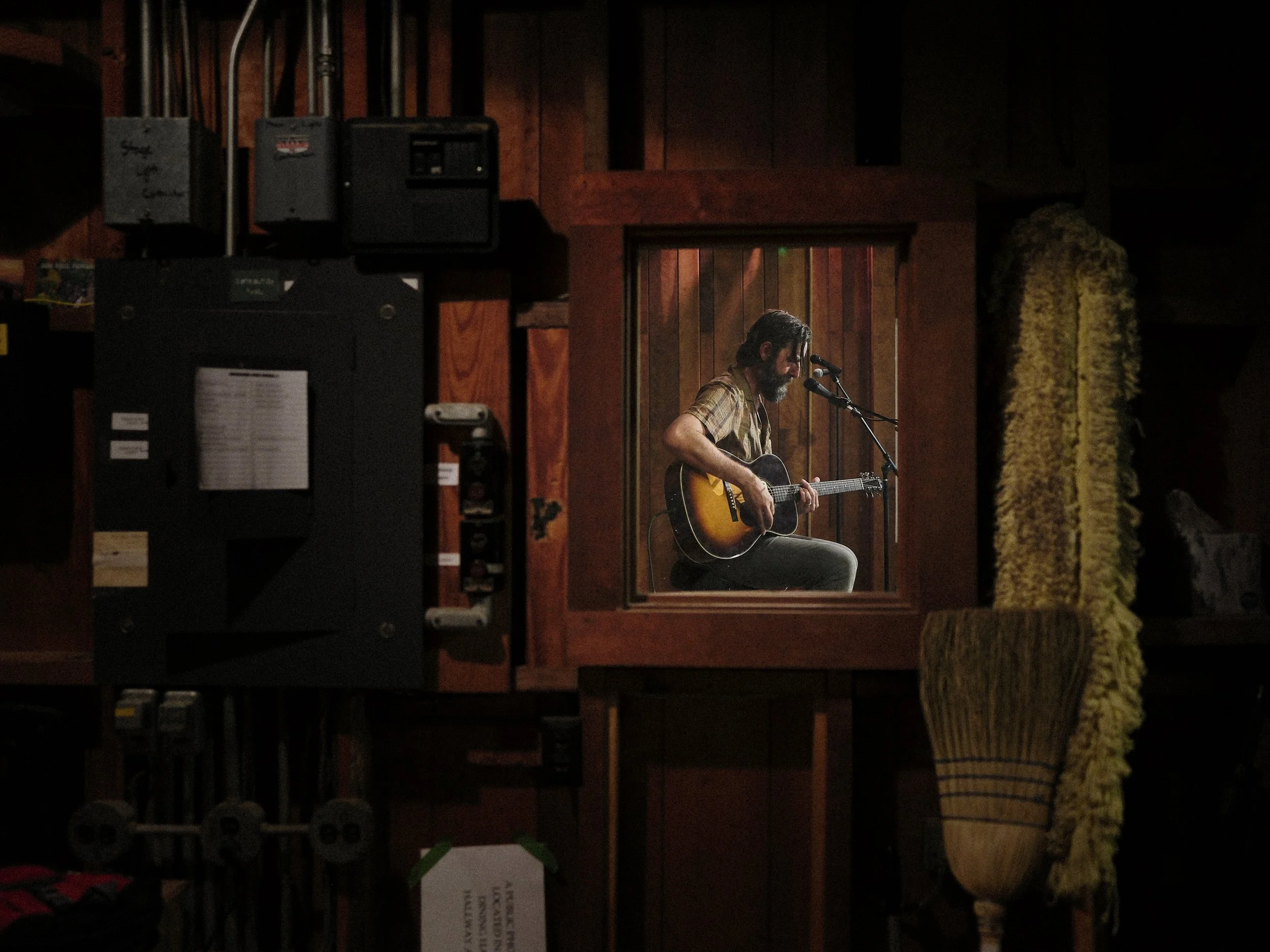 Live stage performance portrait of singer-songwriter Tyler Ramsey playing acoustic guitar under warm stage lighting at Cold Mountain Music Festival, photographed by Parker J. Pfister.