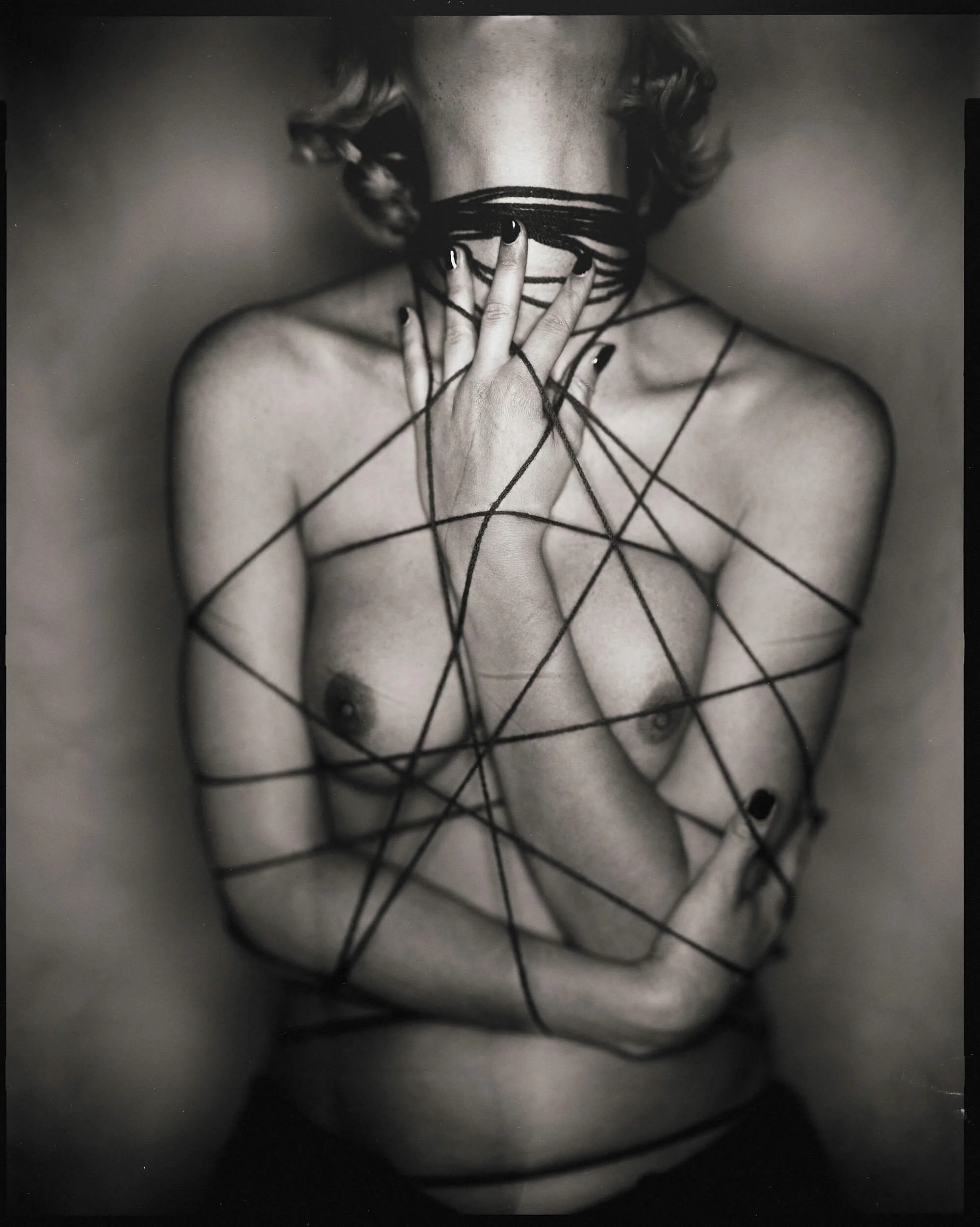 Parker J Pfister Fine Art Black and White Constraint Portrait of the torso of a white woman bound tightly in a black cord.
