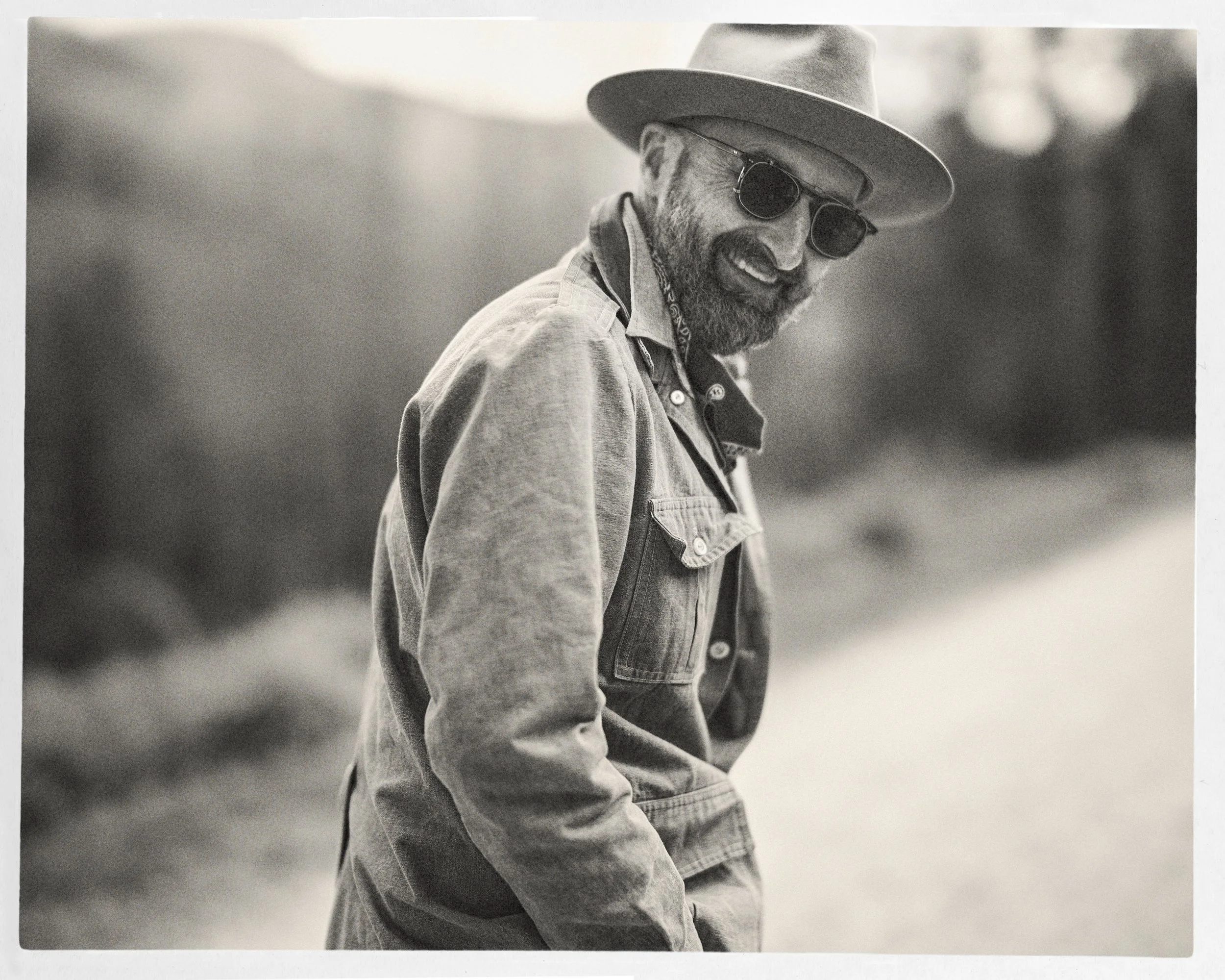 Black and white portrait of singer-songwriter Seth Walker wearing a hat, sunglasses, and jacket outdoors, photographed in Western North Carolina by Parker J. Pfister.