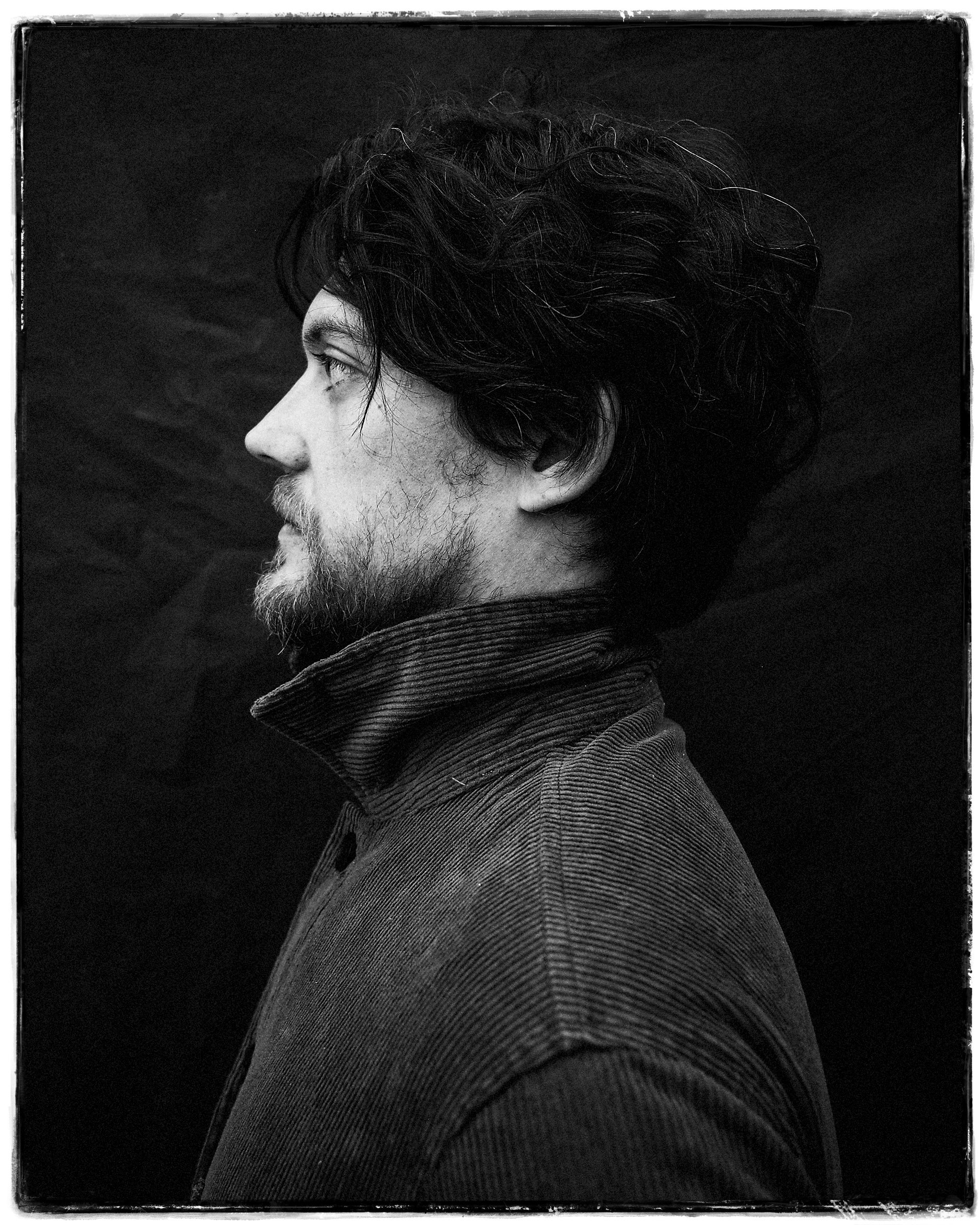 Striking black and white side-profile portrait of guitarist Joey Lee wearing a high-collared sweater, photographed by Parker J. Pfister.