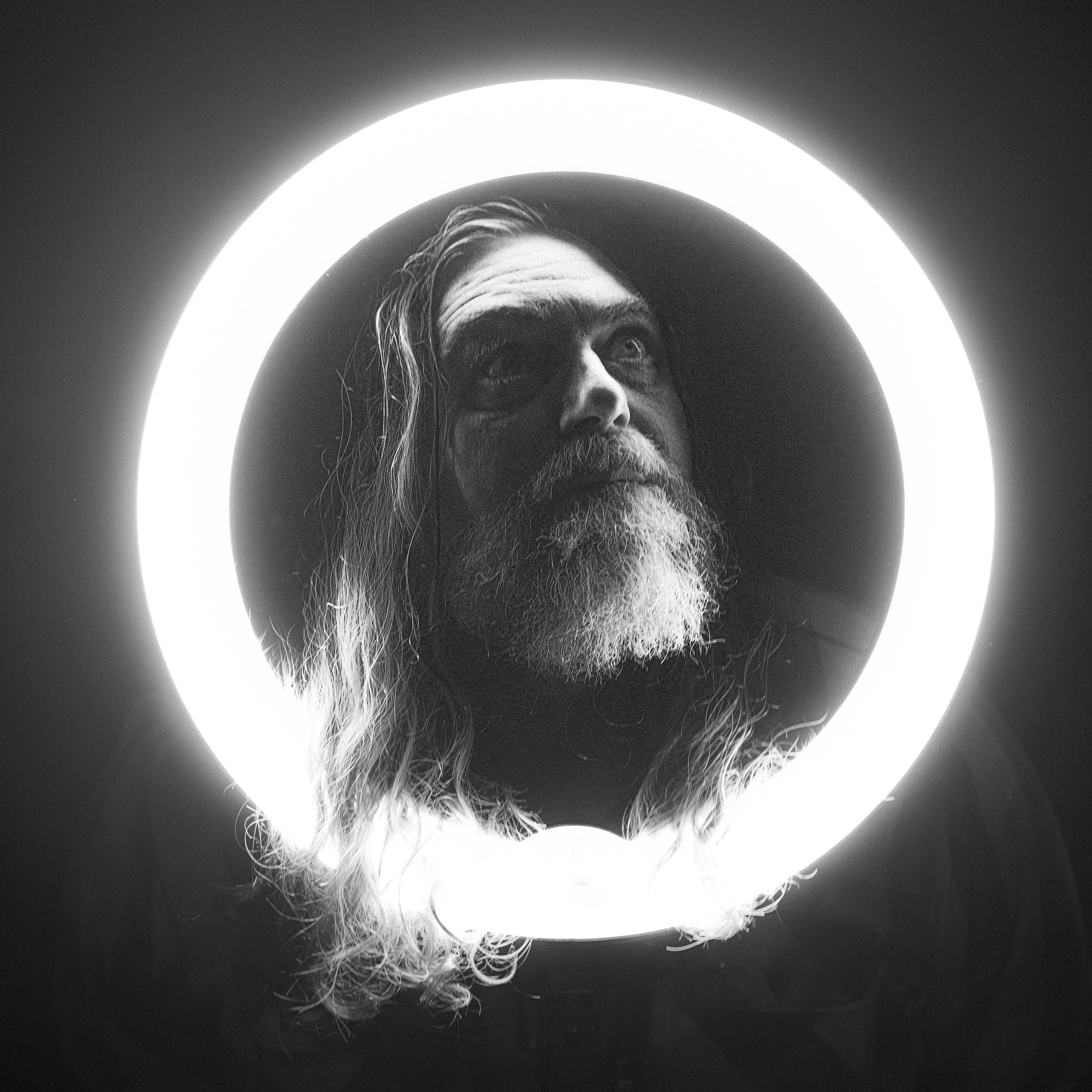 Black and white portrait of musician Jake Smith, known as The White Buffalo, framed within a glowing ring light, photographed by Parker J. Pfister.