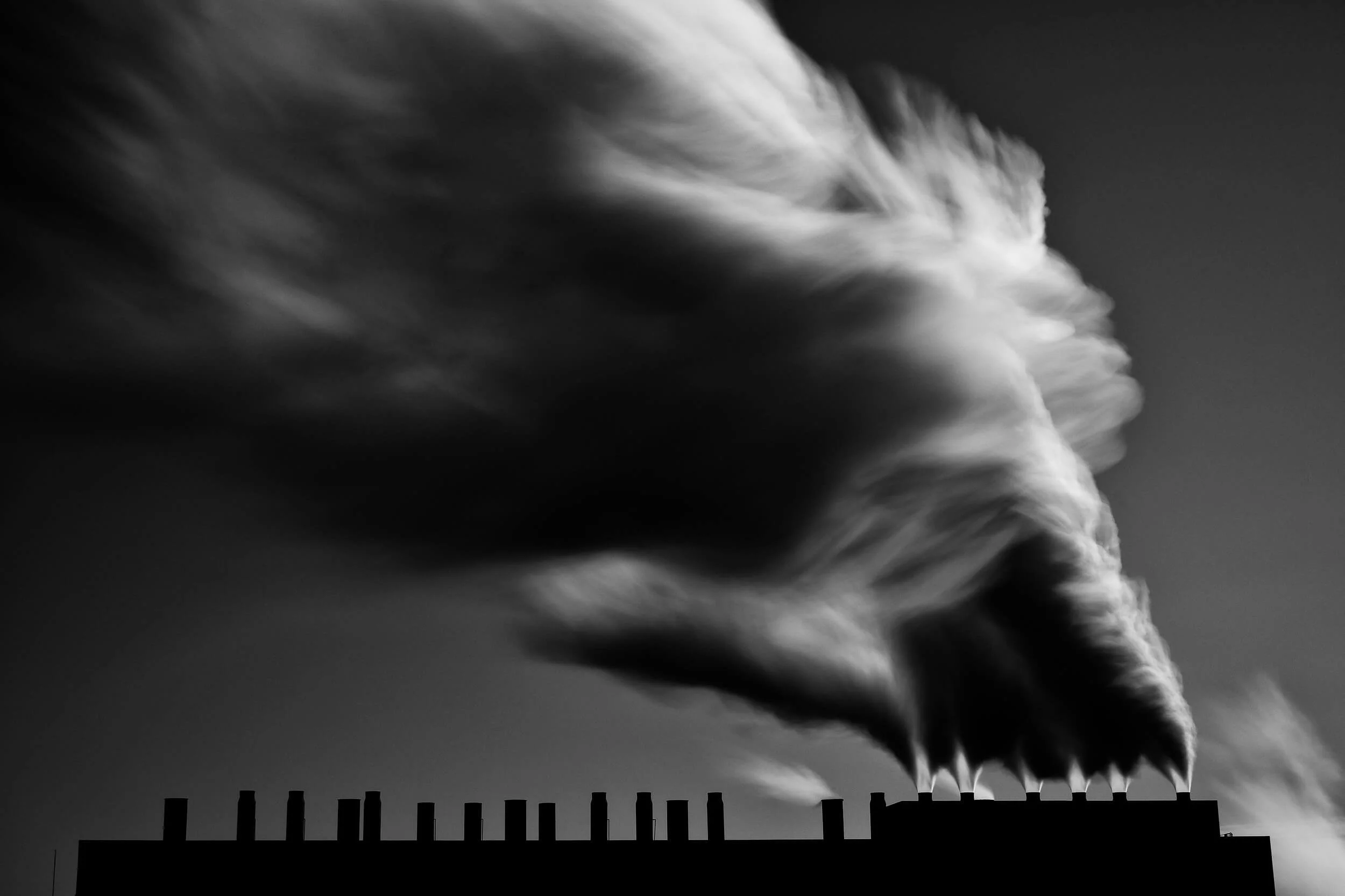 Parker J Pfister Fine Art Man & Land Black and White series of smoke coming out of the chimney of an industrial building. 