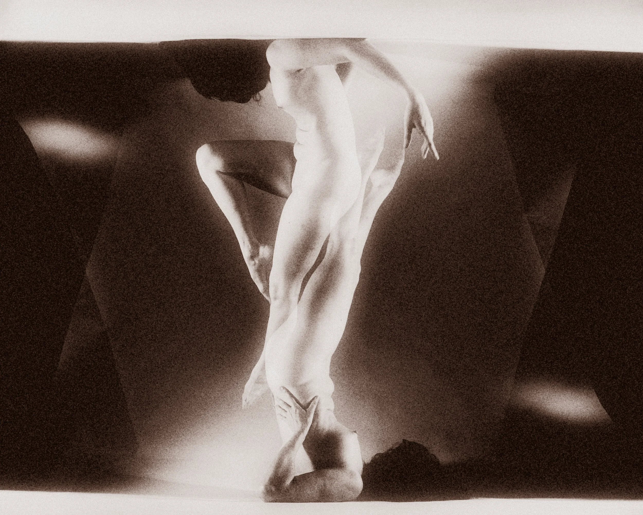An abstract, surreal monochrome fine art nude study featuring mirrored and layered human forms in motion, creating a striking geometric and textured balance.