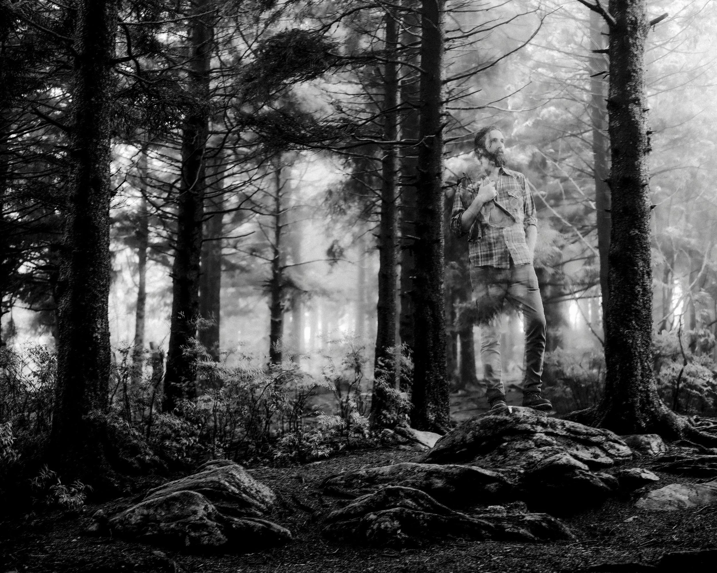 Atmospheric black and white fine art portrait double exposure of singer-songwriter Tyler Ramsey standing in a misty forest for his album New Lost Ages, photographed by Parker J. Pfister.