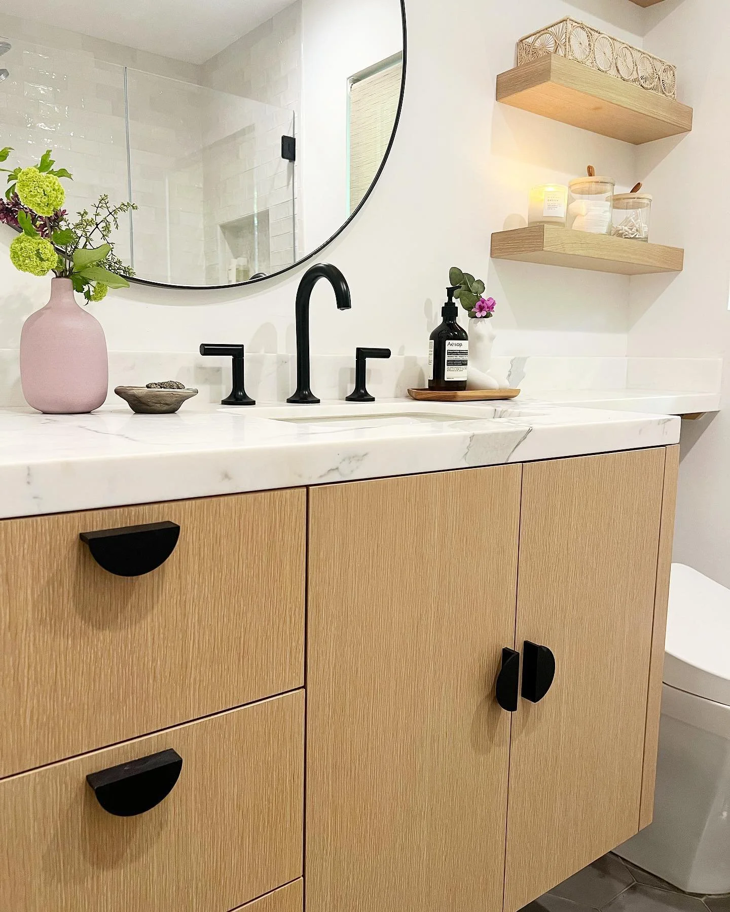 Floating white oak vanity. Light white wash finish with clear top coat. Matching floating shelves. Creating space under the vanity and removing closed cabinets makes it easy to make a tiny bathroom feel open. Deep drawers provides more storage abilit