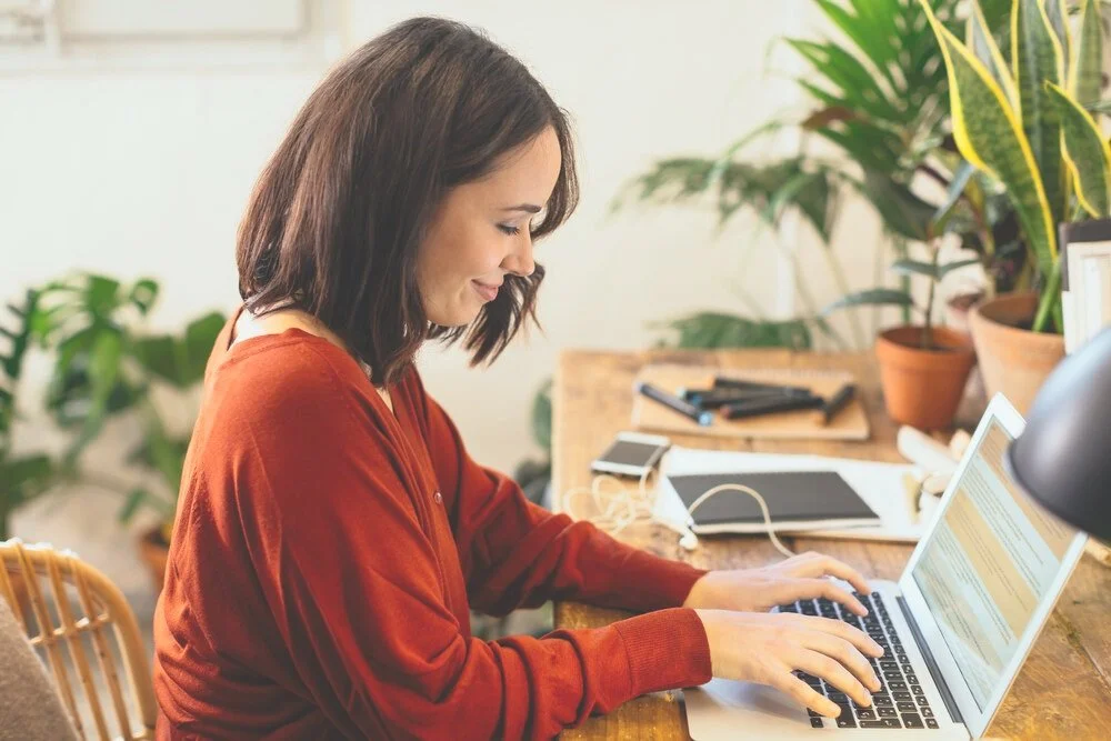 A relaxed woman using a laptop in a calm home setting
