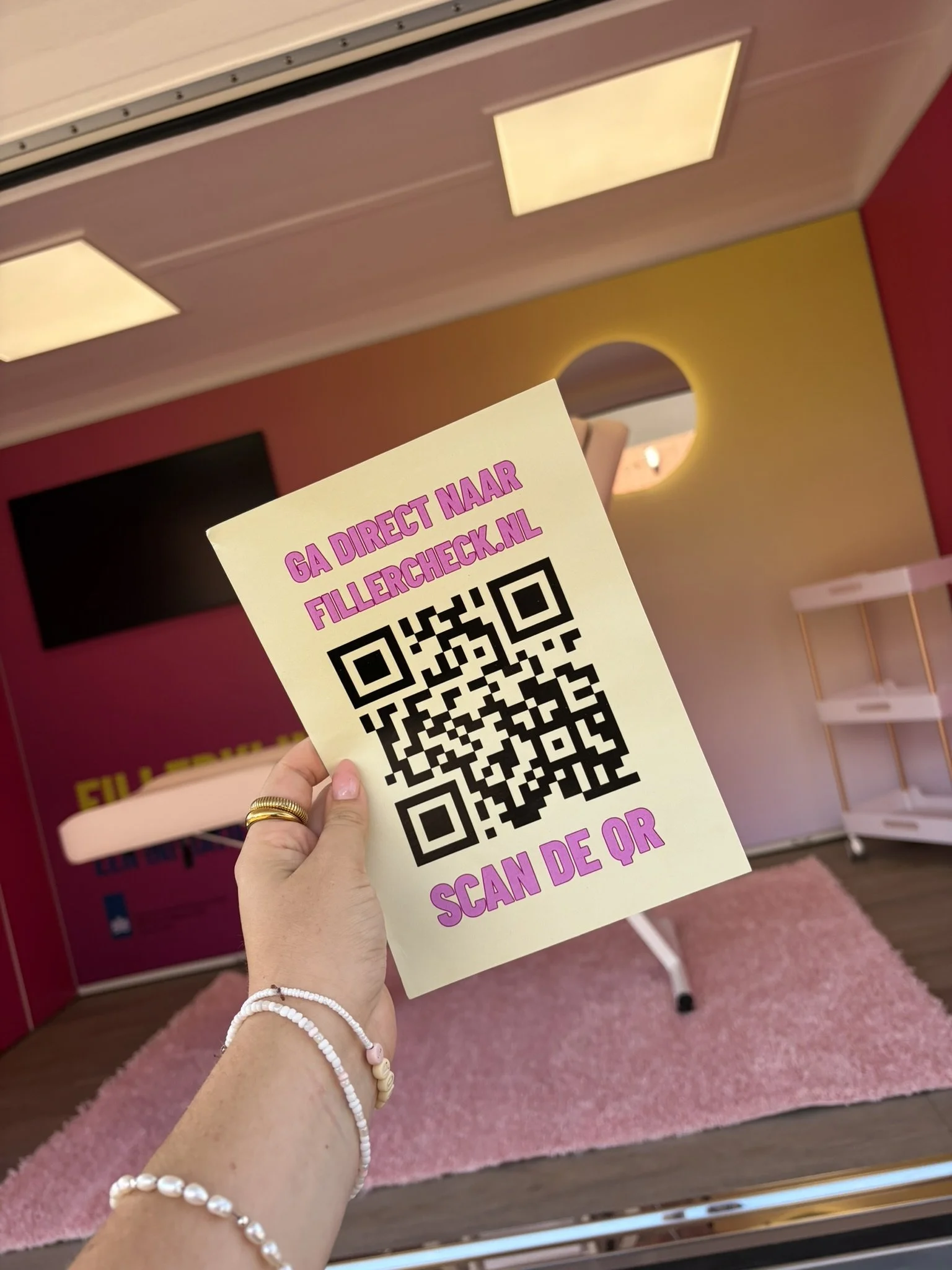 vrouw houdt poster omhoog met qr code fillercheck igj tranzo en wiemooiwilzijn