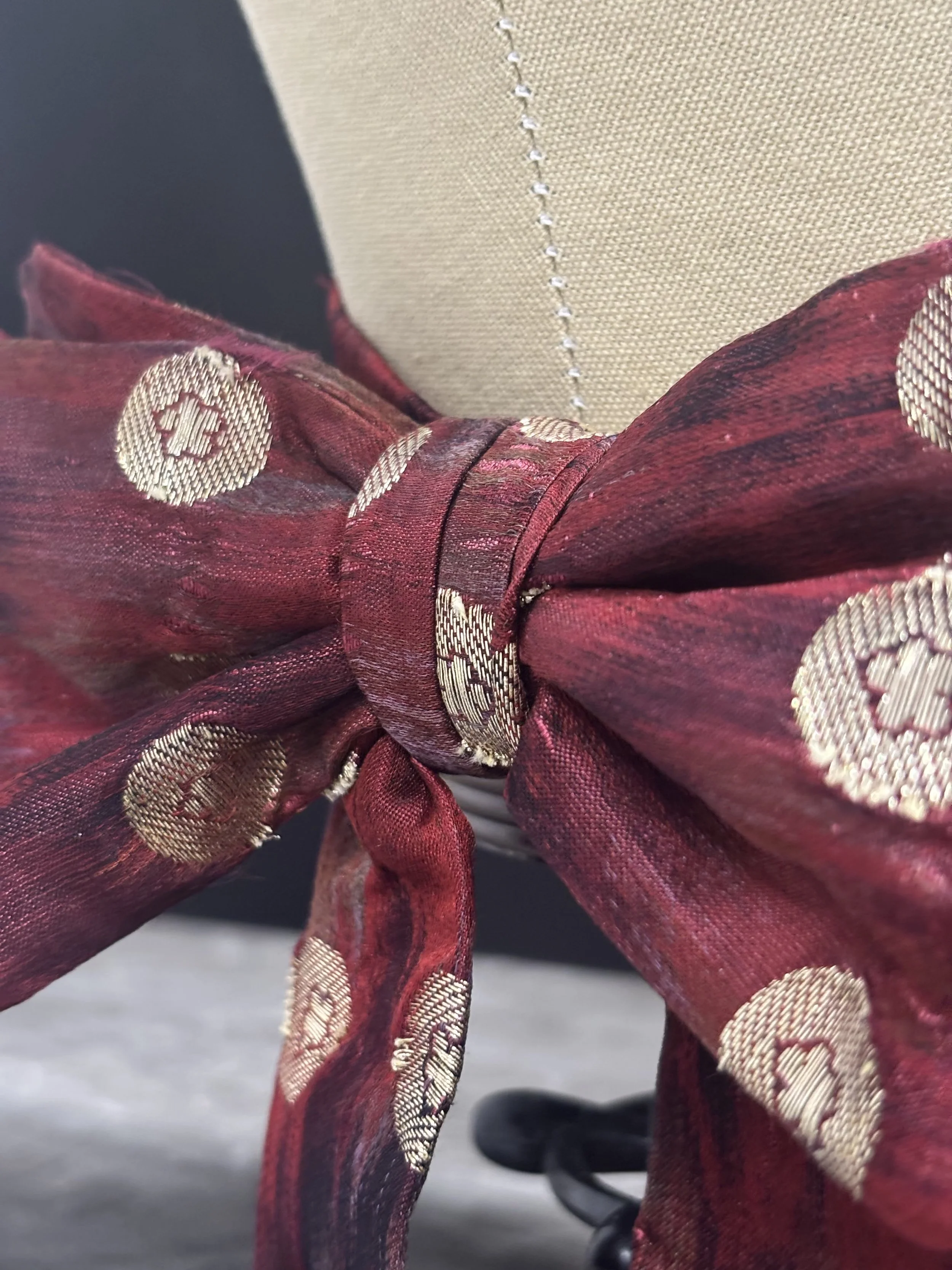 Bowtie patterned and sewn in silk. Adjustable sizes on band with hooks and bars.