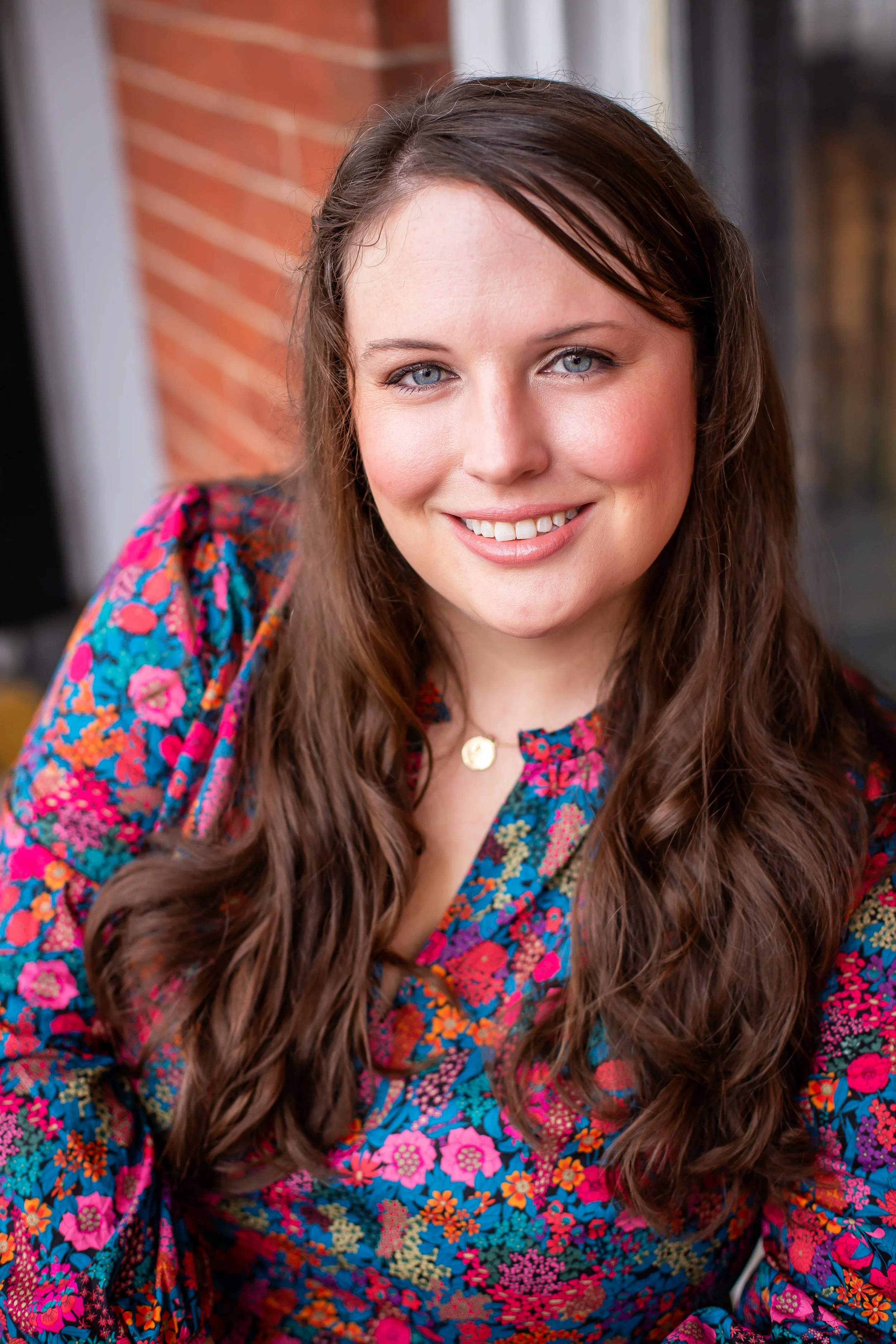 Picture of Elise wearing a floral dress smiling at the camera