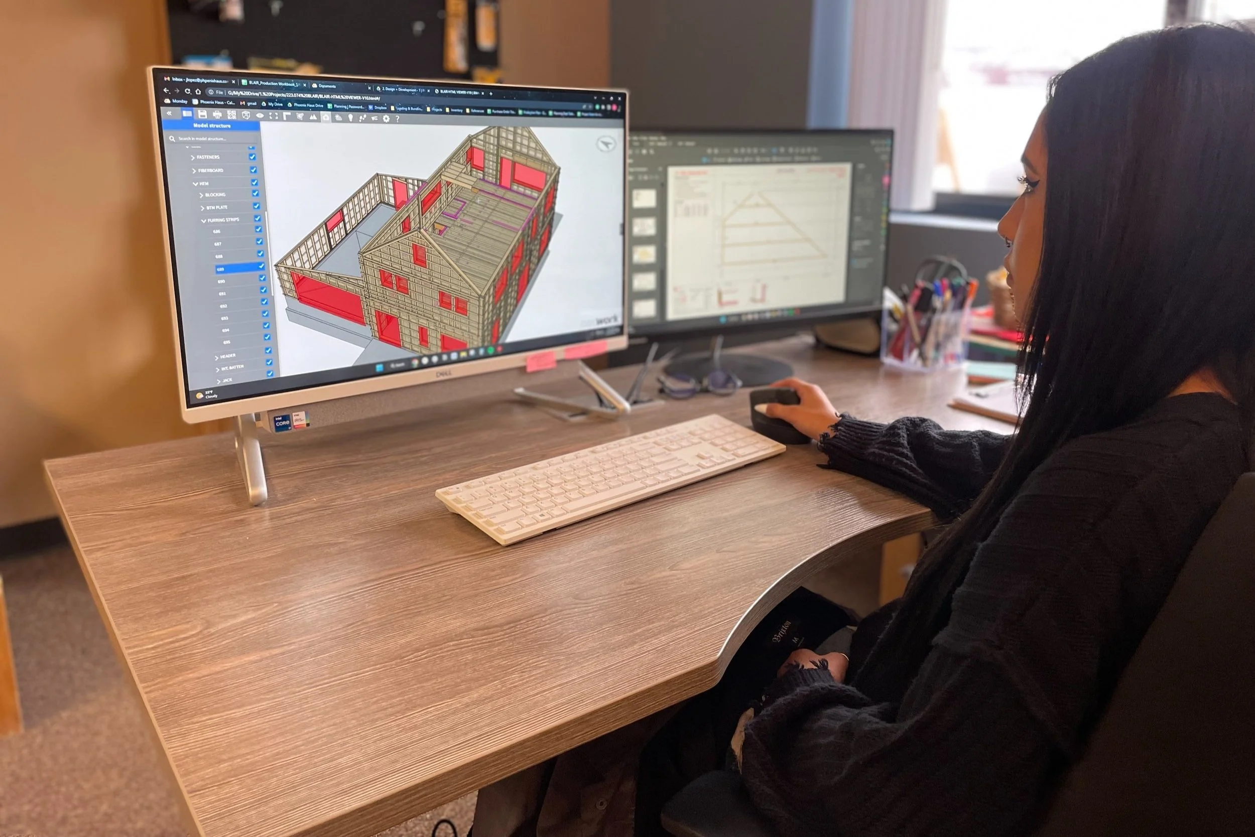 an employee designs a modular home plan on her computer