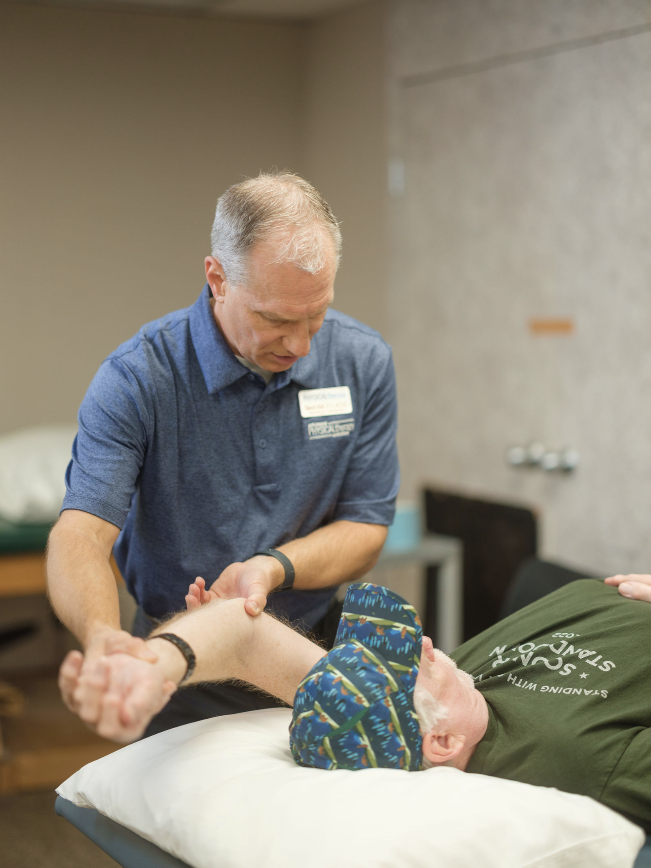 A physical therapist assists a patient with arm mobility exercises during a rehabilitation session.