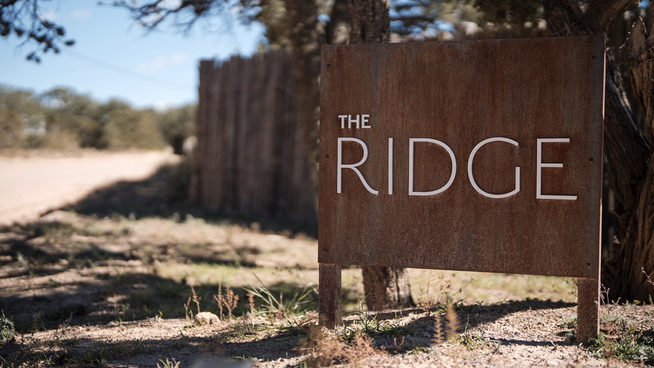 The Ridge Santa Fe wedding venue sign corten steel desert landscape