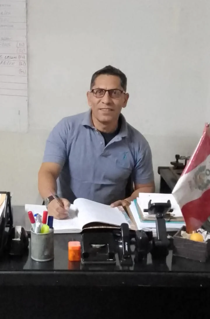 Man writing at desk in book / Hombre escribiendo en un libro en su escritorio