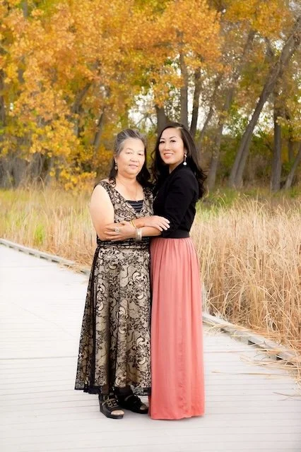 Asian woman and her mother on a bridge holding arms representing Asian therapist in Portland, Oregon for depression, anxiety, relationships, stress, and parenting.