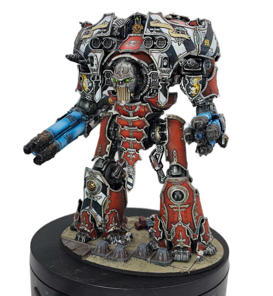 A detailed model of a Warhammer 40K Space Marine in red armor with skull motifs, wielding weapons, and standing on a decorated base.
