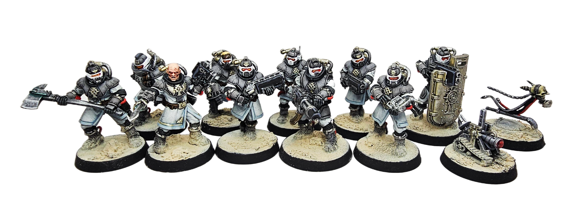 Miniature figures of sci-fi soldiers in armor, holding weapons, with one figure in robes and a bald head, on round bases.