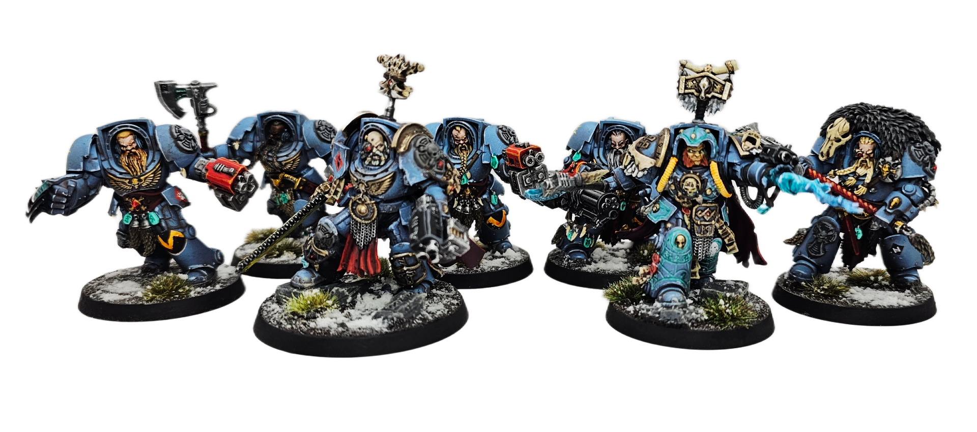 Seven intricately painted Warhammer 40K miniature figures in blue armor, equipped with weapons, standing on snow-covered bases with small patches of grass.