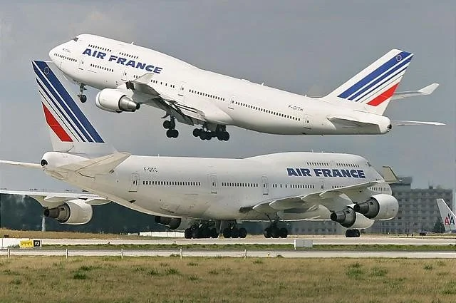  Two Boeing 747 400s of Air France, one climbing out while the the other taxis. 