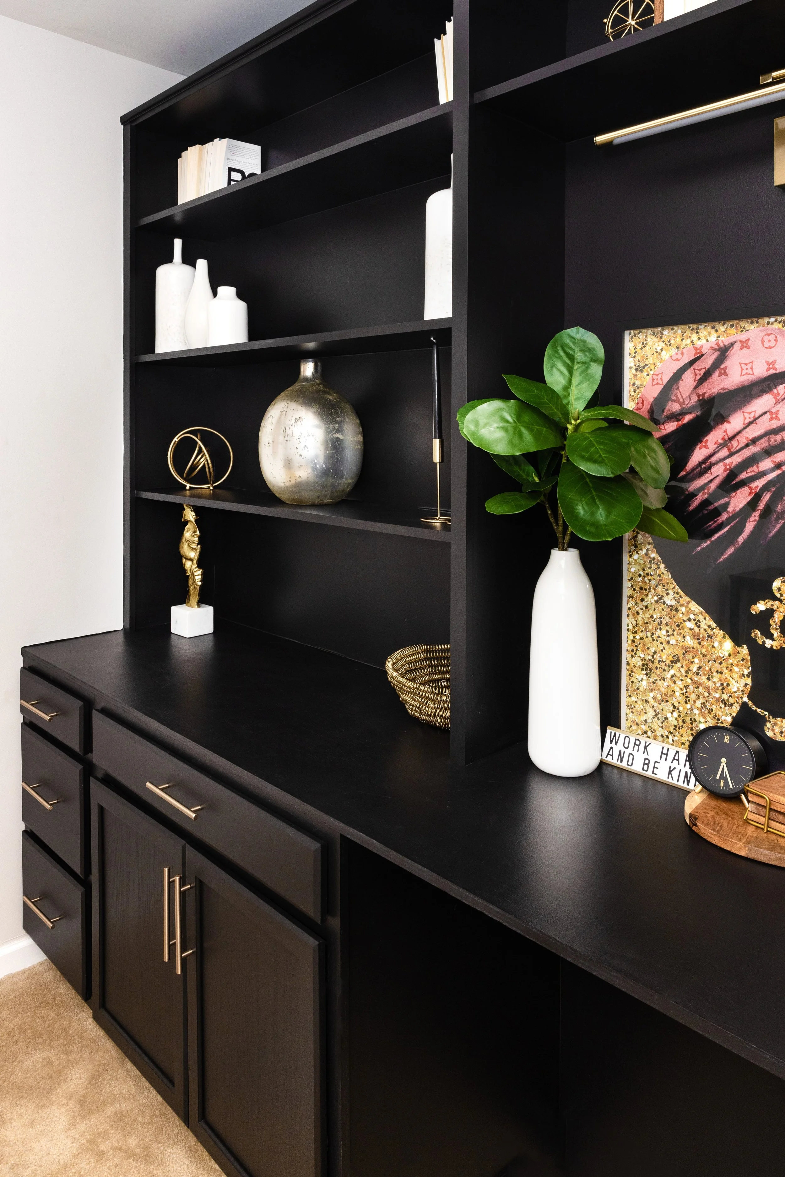 A modern luxury home office with black built-in shelving and gold accents designed by a residential interior designer in Washington DC.