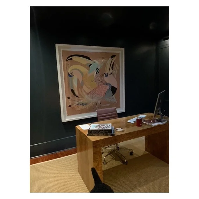 Hermes scarf elegantly floating on a white mat, creating depth while keeping the focus on its intricate design.  Framed in a deep white moulding, which creates a bold contrast against the deep blue wall.