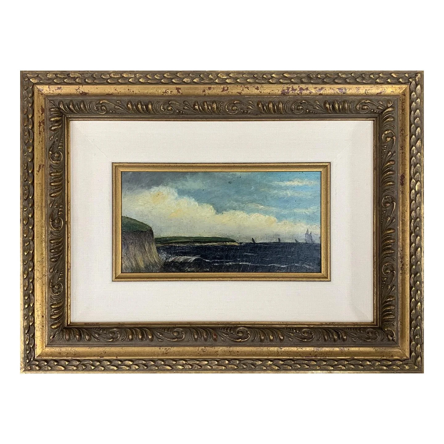 Miniature antique seascape paintings elegantly framed in an ornate gold frame with intricate detailing. A linen liner adds depth and size, complemented by a gold fillet that highlights the coastal scene.
