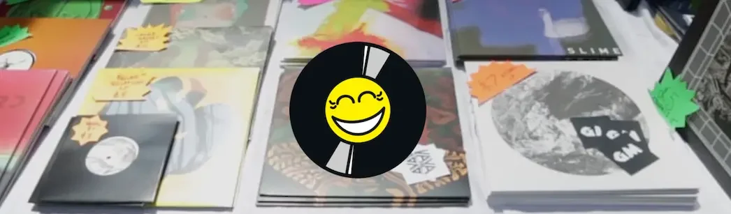 Vinyl records spread across a stall at the Independent Label Market, Coal Drops Yard, London, with the Disco Pogo smiley face logo in the foreground