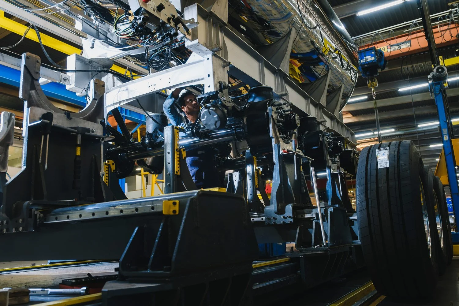 Actiefoto van een mechanicien onder het frame van een vrachtwagen.jpg