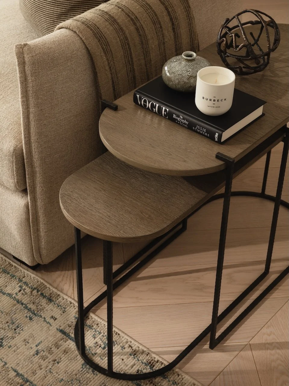 Modern oak nesting side tables with black metal frames, styled in a luxury living room setting. Premium designer furniture from Burbeck Interiors, ideal for contemporary homes, interior design projects and property staging.