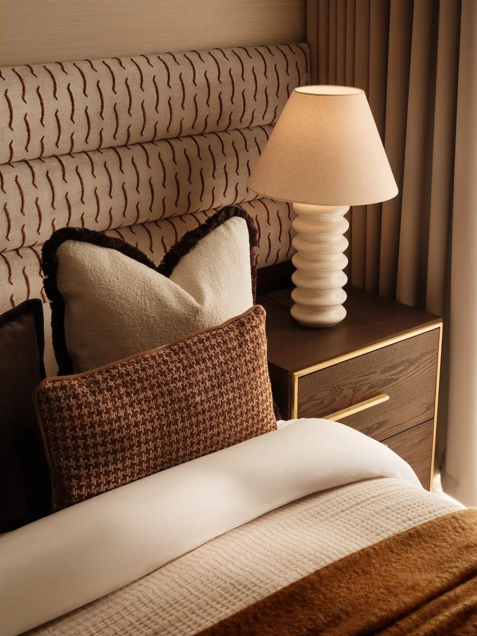 Award-winning London Square show home bedroom designed by Burbeck Interiors, showcasing bespoke upholstery, luxury textiles, designer lighting and carefully curated furniture to create an aspirational living environment.