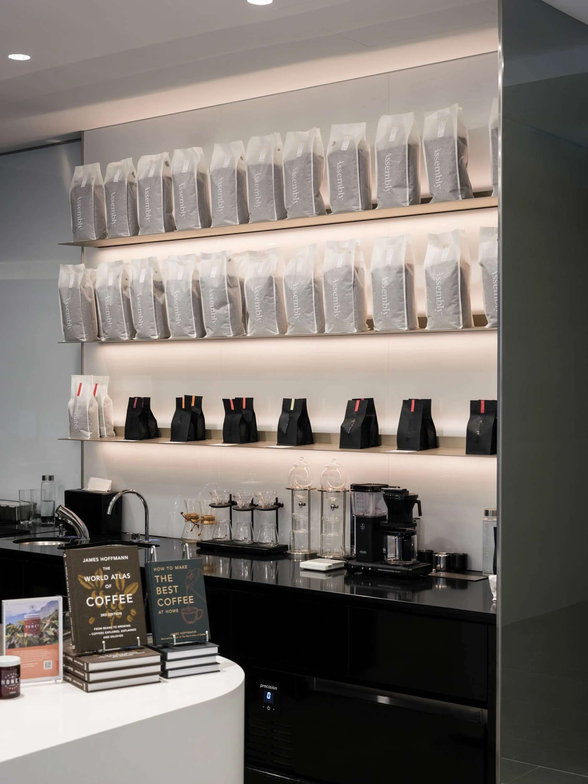 Retail coffee bags displayed on illuminated shelving, café design, London