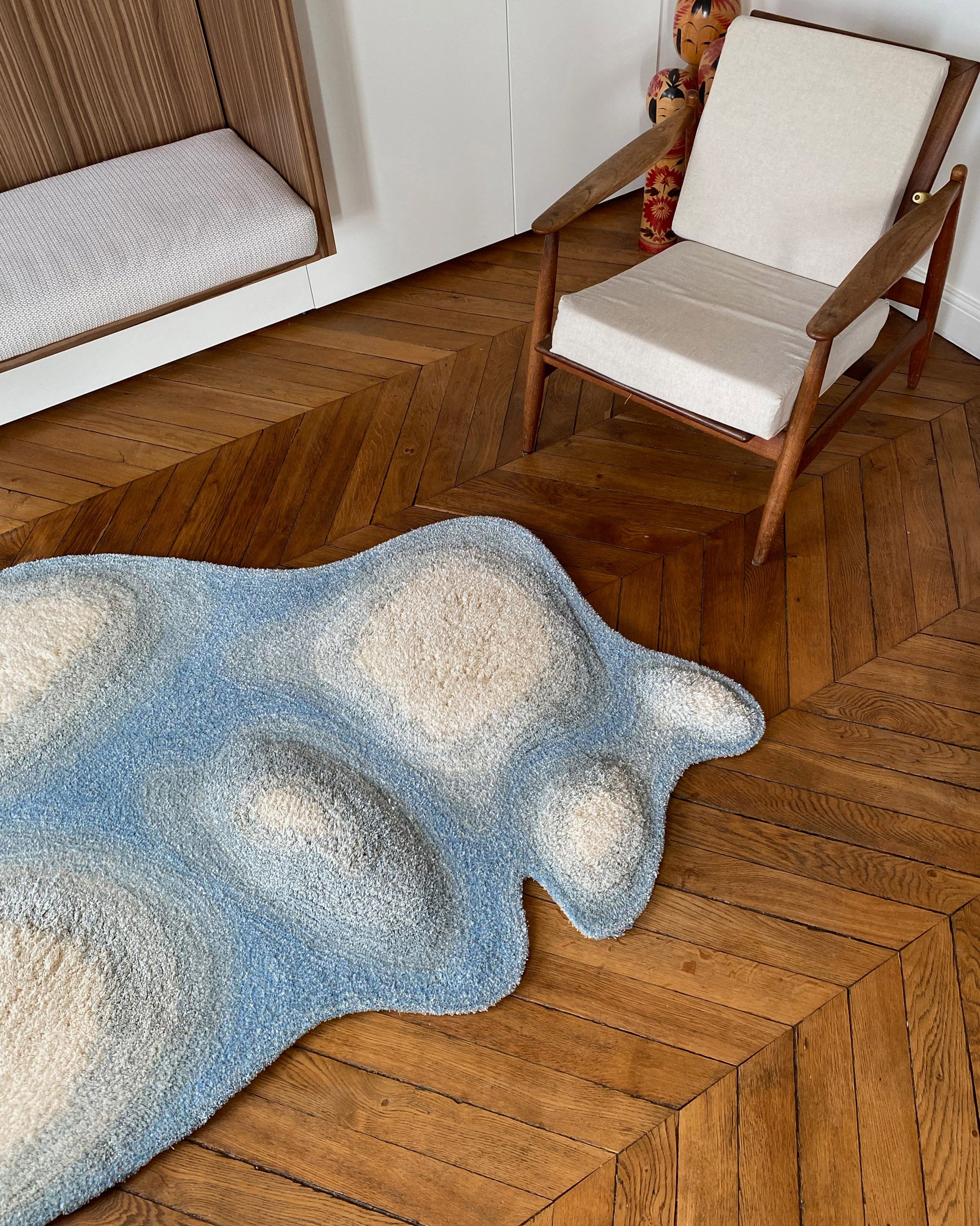 SNÖ Small. Rug on floor with wooden chair.